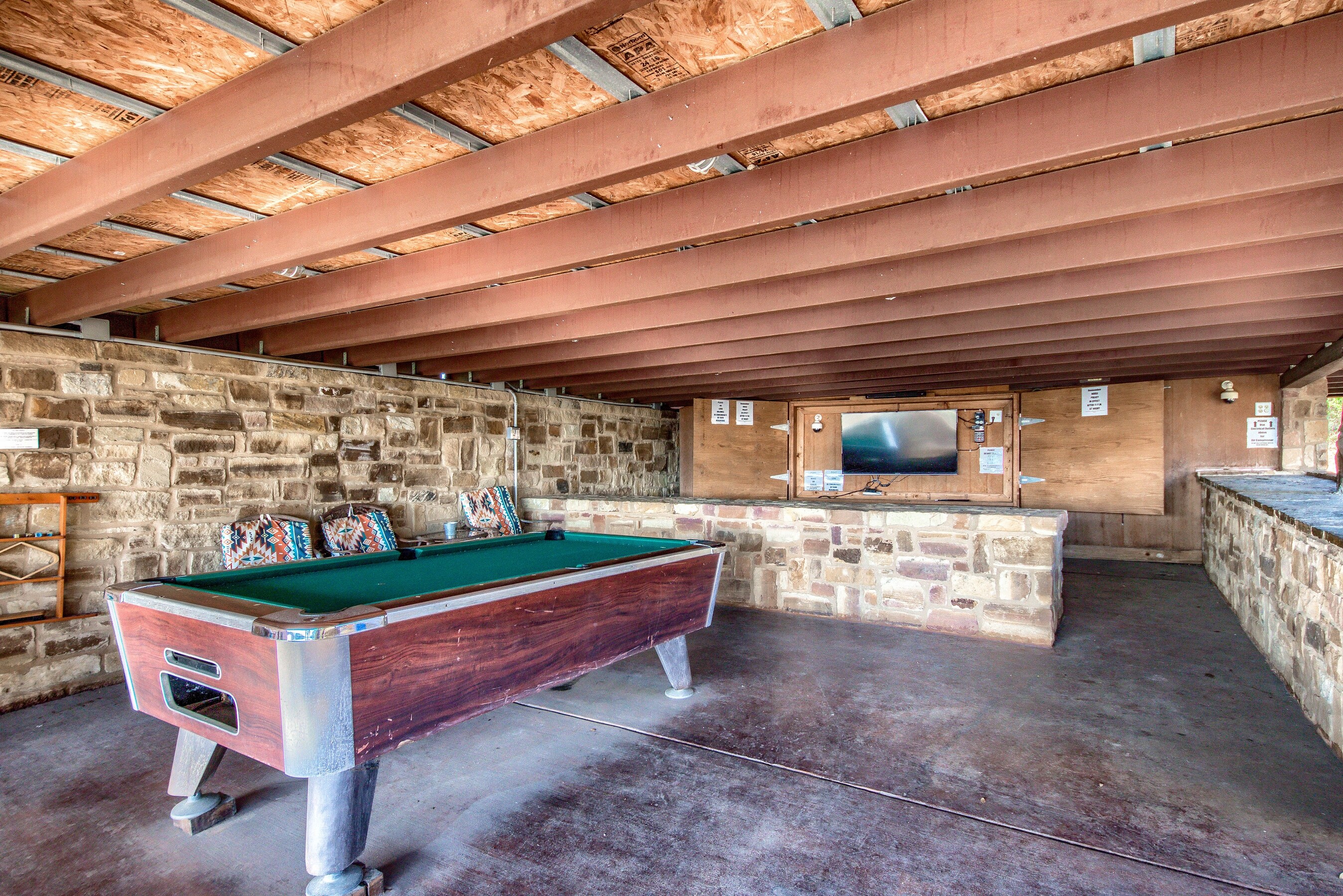 Covered outdoor area with smart TV and pool table
