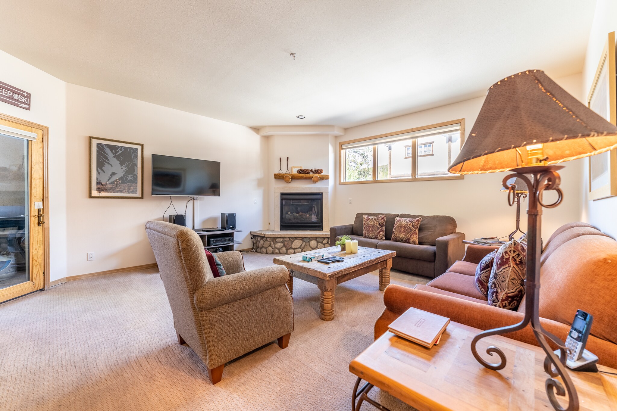 Spacious living area featuring ample seating, gas fireplace, and large flat screen TV. 