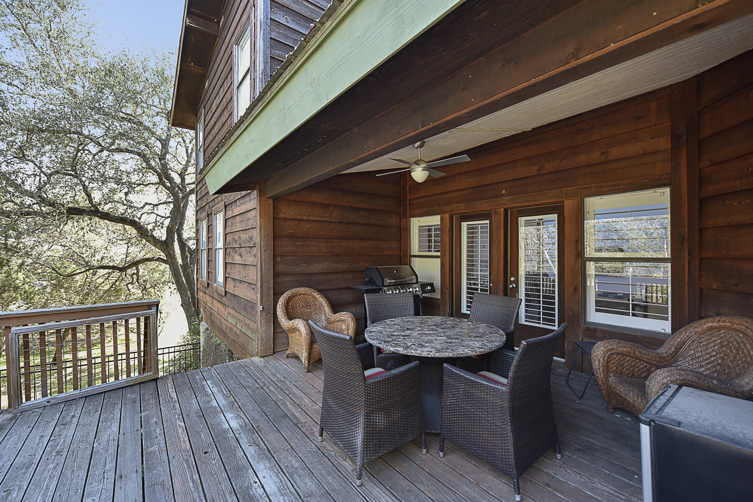 A grill and outdoor dining on the large wooden deck