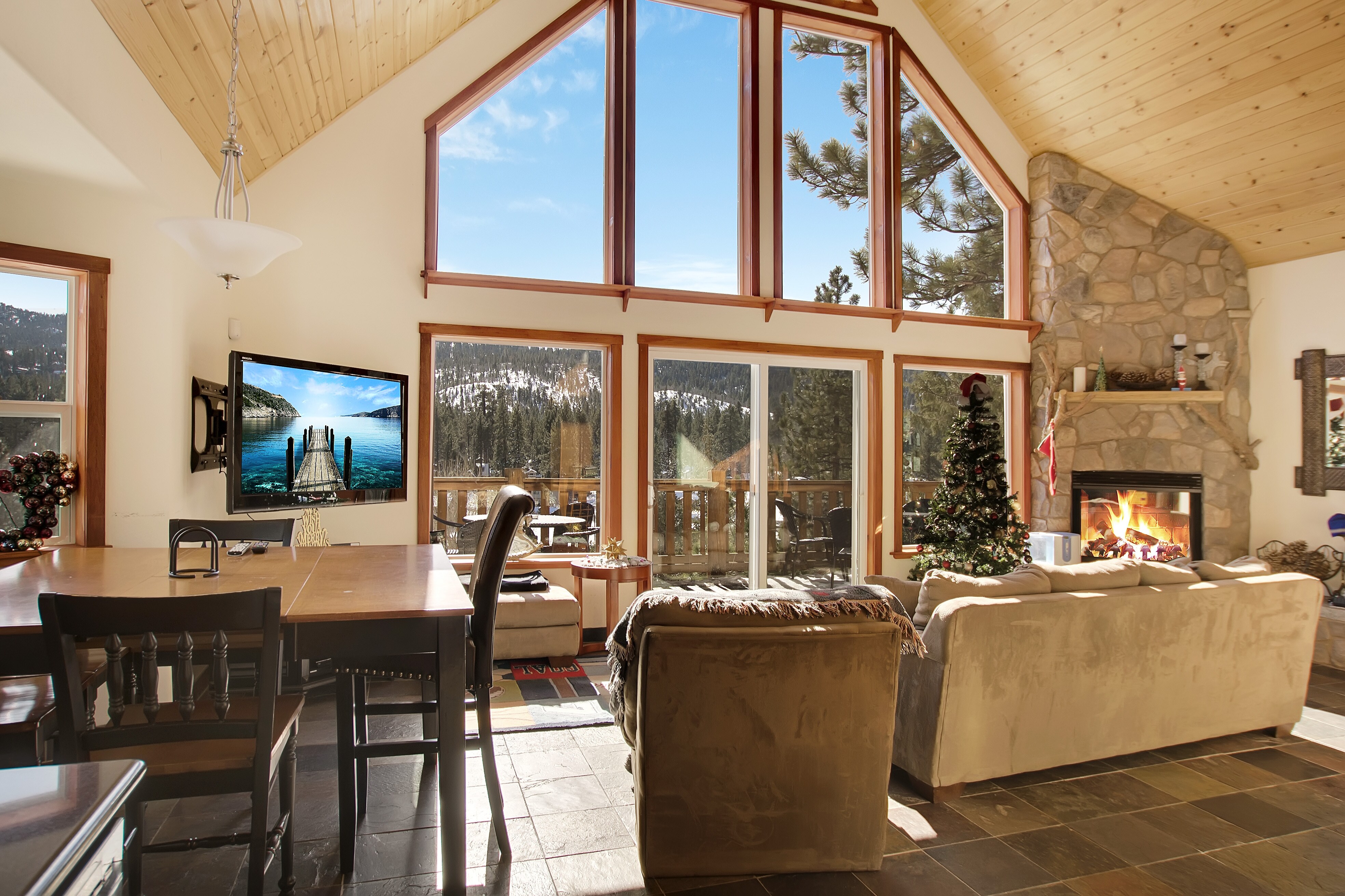 A sun-soaked open living area has seating for 5 across from the 55” Toshiba wall-mounted TV