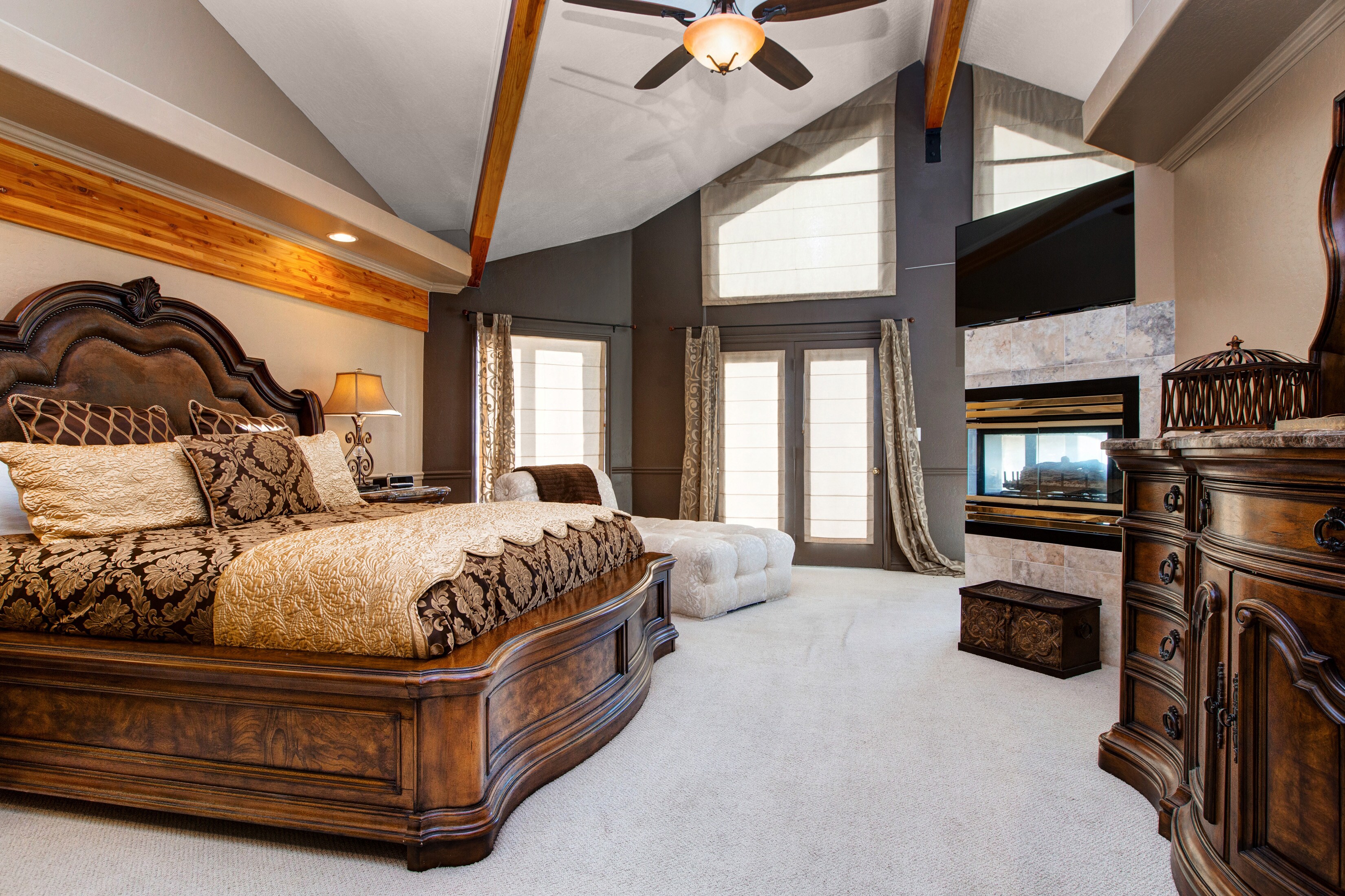 The magnificent master bedroom has a king-size bed, chaise lounge, and a 50” flat-screen