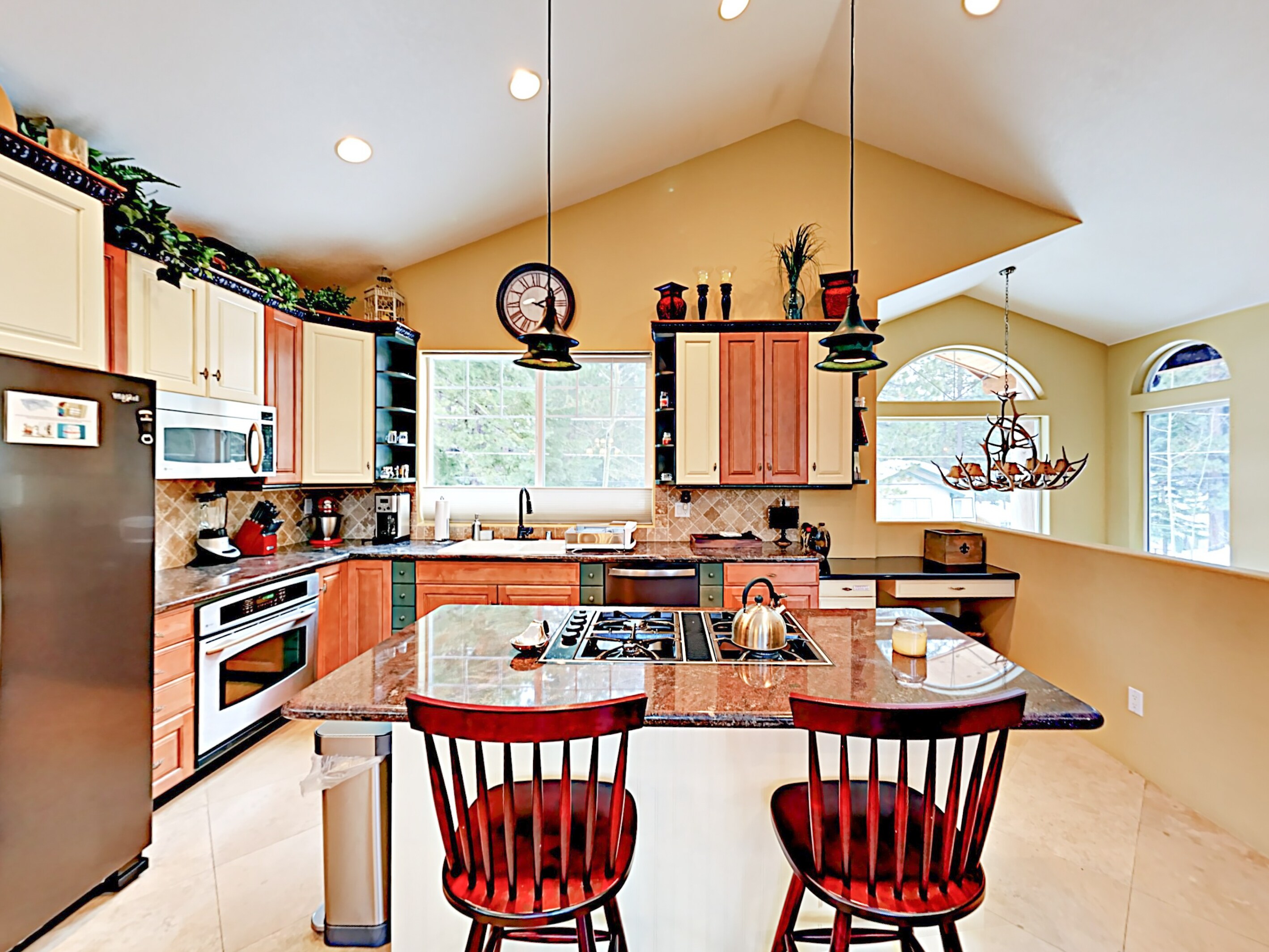 The huge open-concept kitchen features granite countertops and an array of cookware.