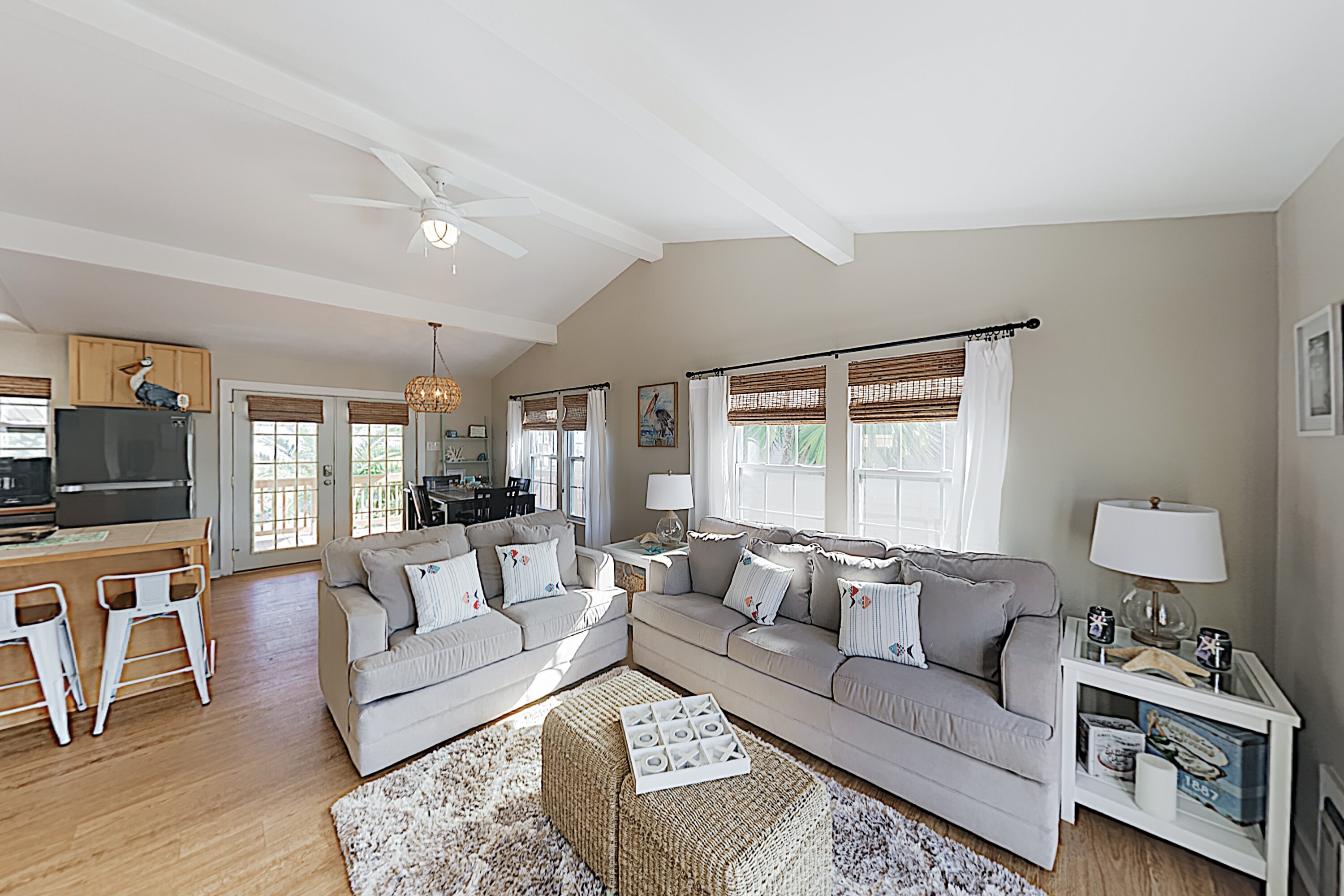 Natural light floods the welcoming living room, which is furnished with a queen-size sleeper sofa.