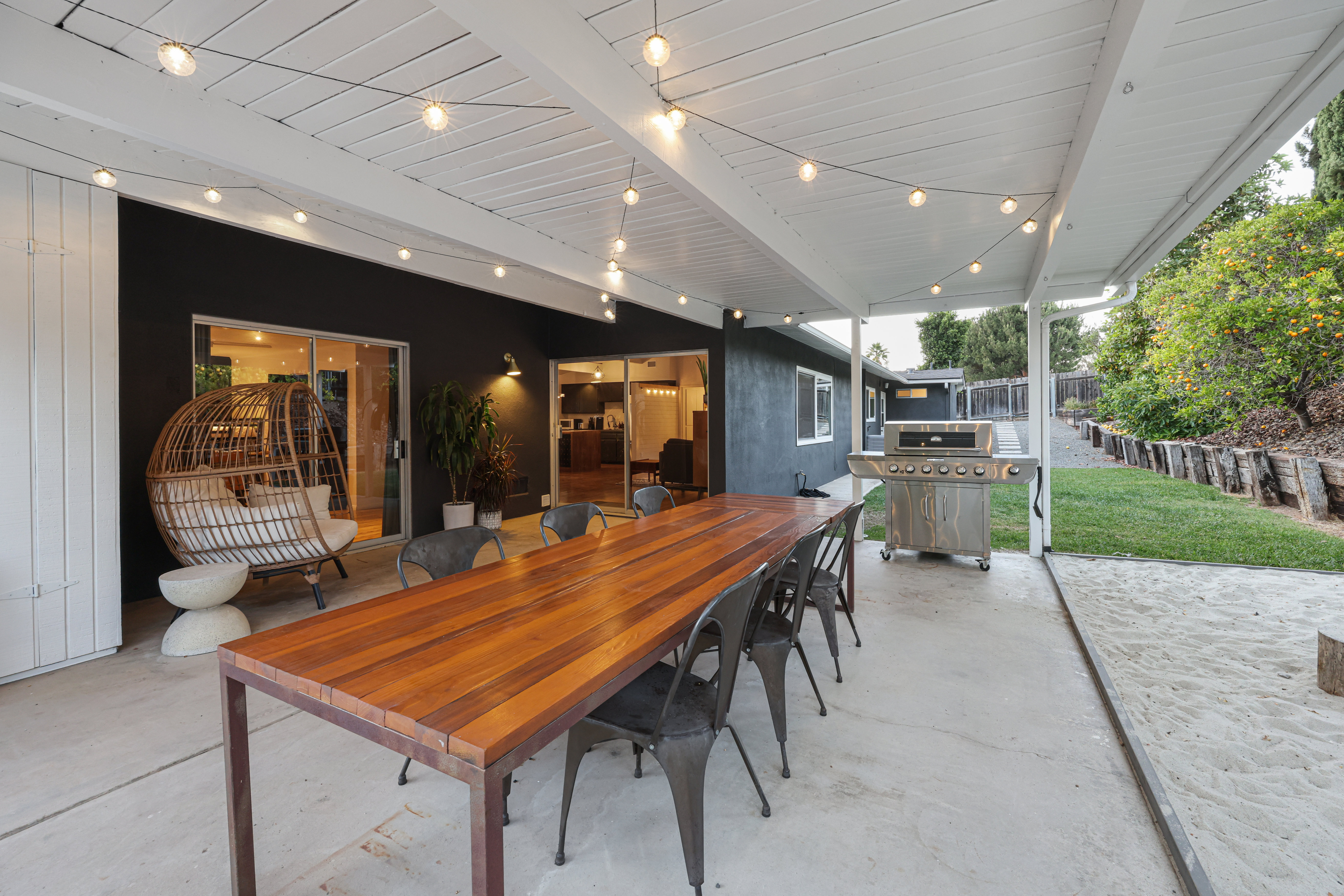 Patio with covered dining table and chairs, a BBQ Grill and loungers