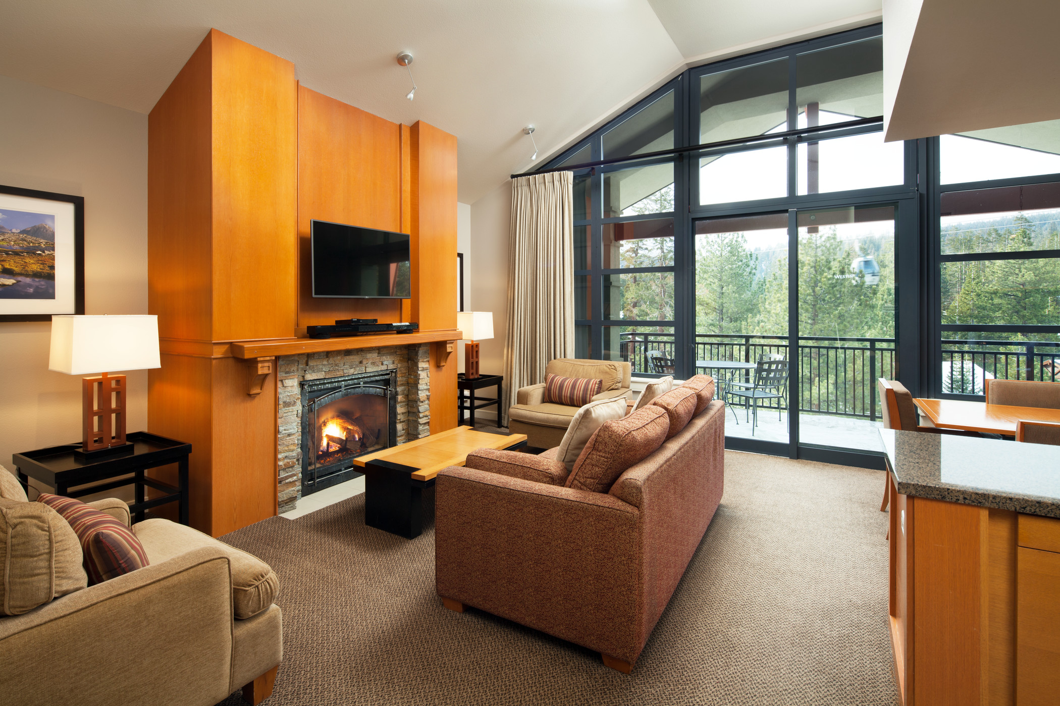 Modern living and dining areas with fireplace, window wall and balcony