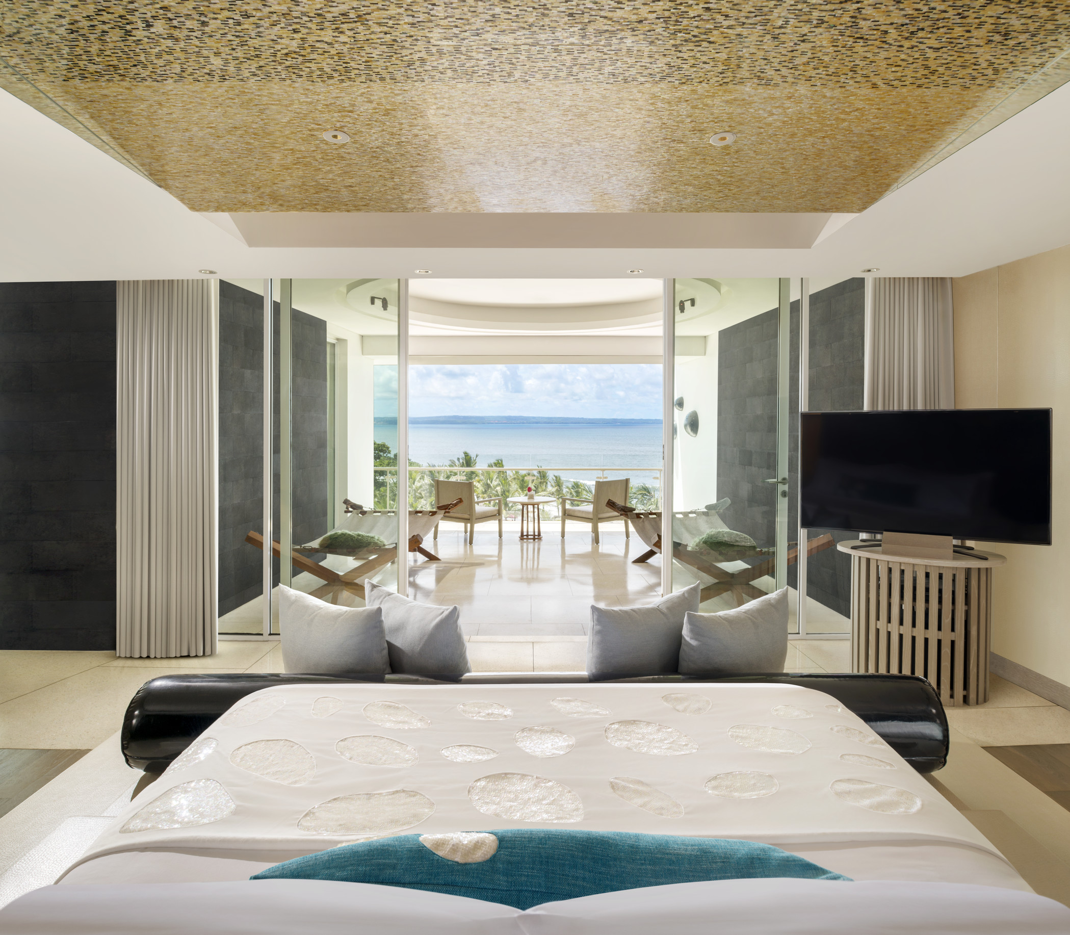 Large modern bedroom with seating overlooking ocean