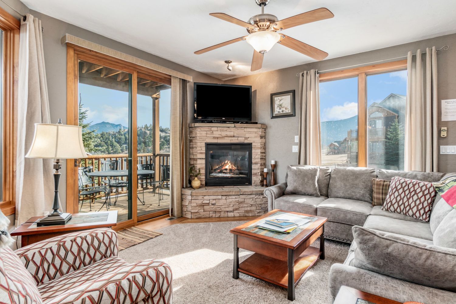 Mount Cirrus 10B - Large living room with oversized chair and L shaped sofa. Flat screen TV with gas fireplace and panoramic views out the sliding glass doors. 