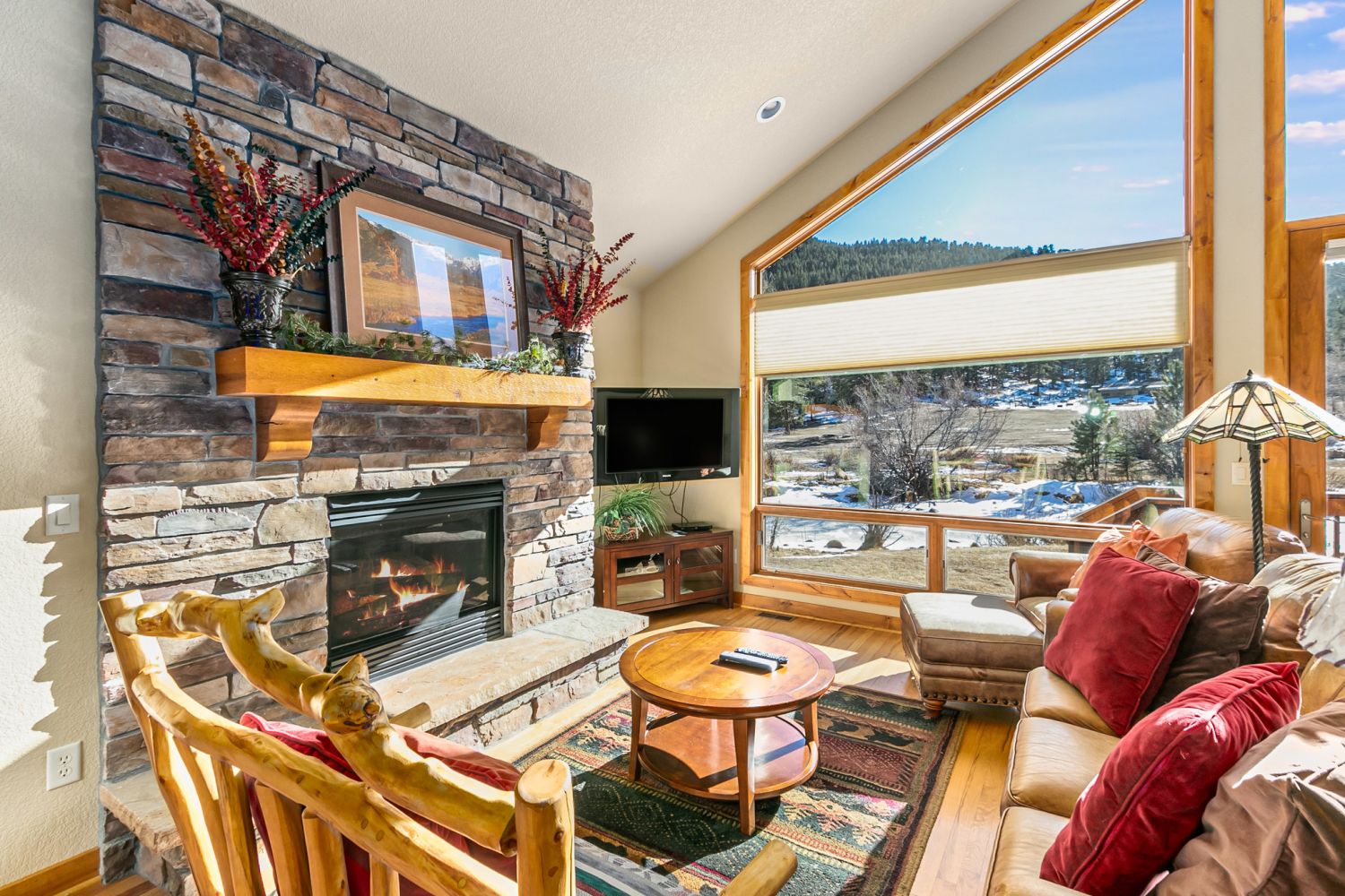 Tranquility on the River Three - Large open living with plenty of comfy seating for all, floor to ceiling windows with a river view, and cozy gas fireplace.