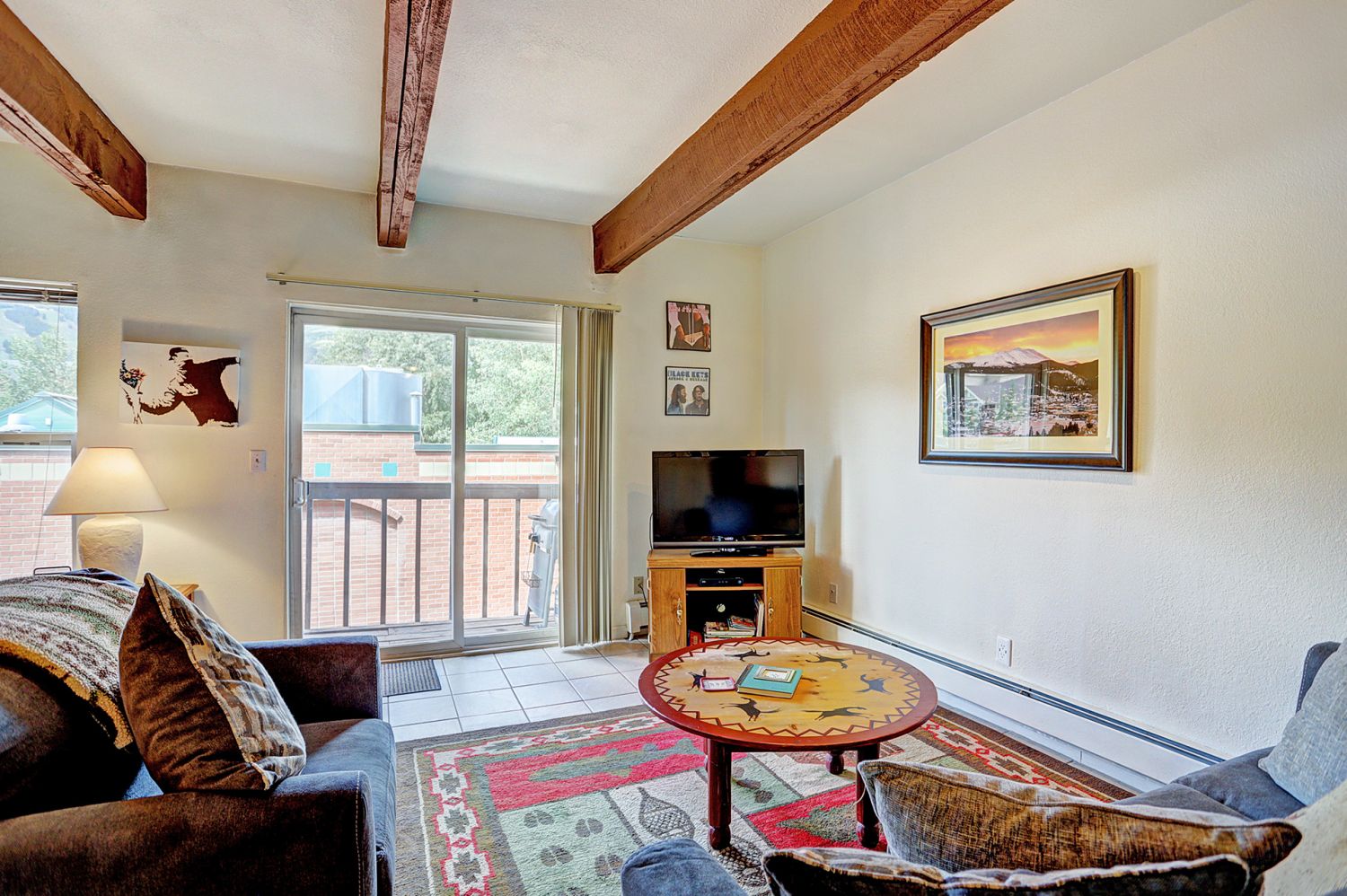Living room with flat screen TV, wood fireplace, and walk-out balcony  - 