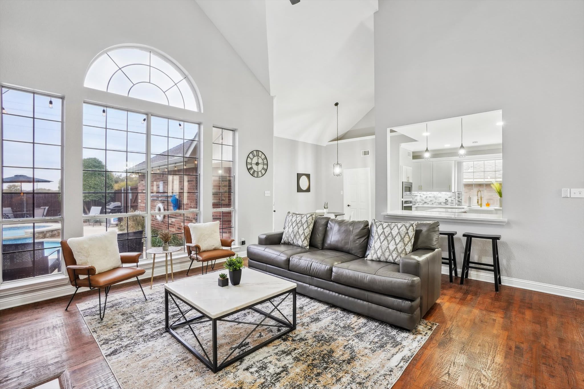 With high-vaulted ceilings and an impressive wall of windows, this living room is a modern, multi-functional space just waiting for you to experience it!