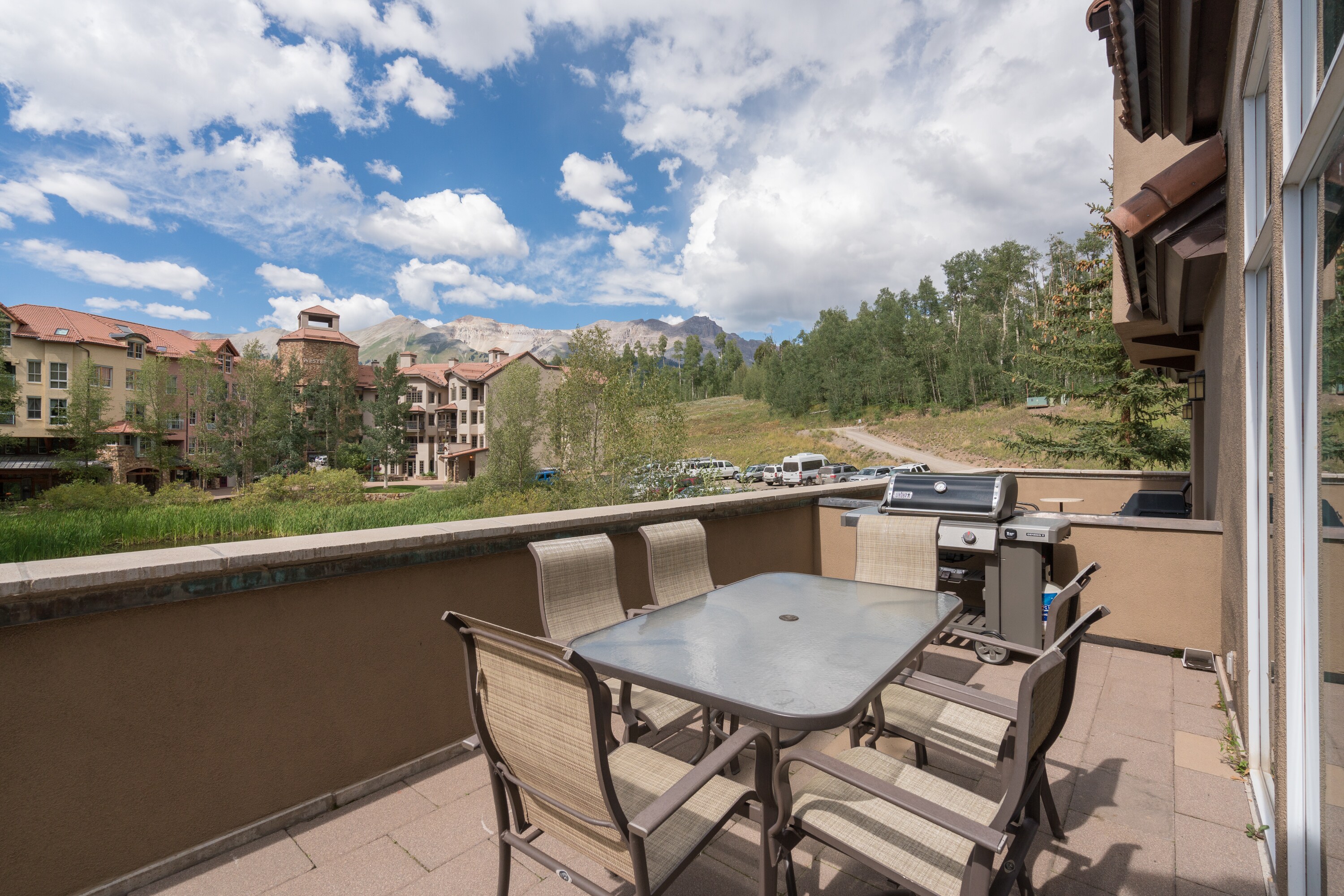 Condo features a balcony with a grill, outdoor dining table, and breathtaking views.