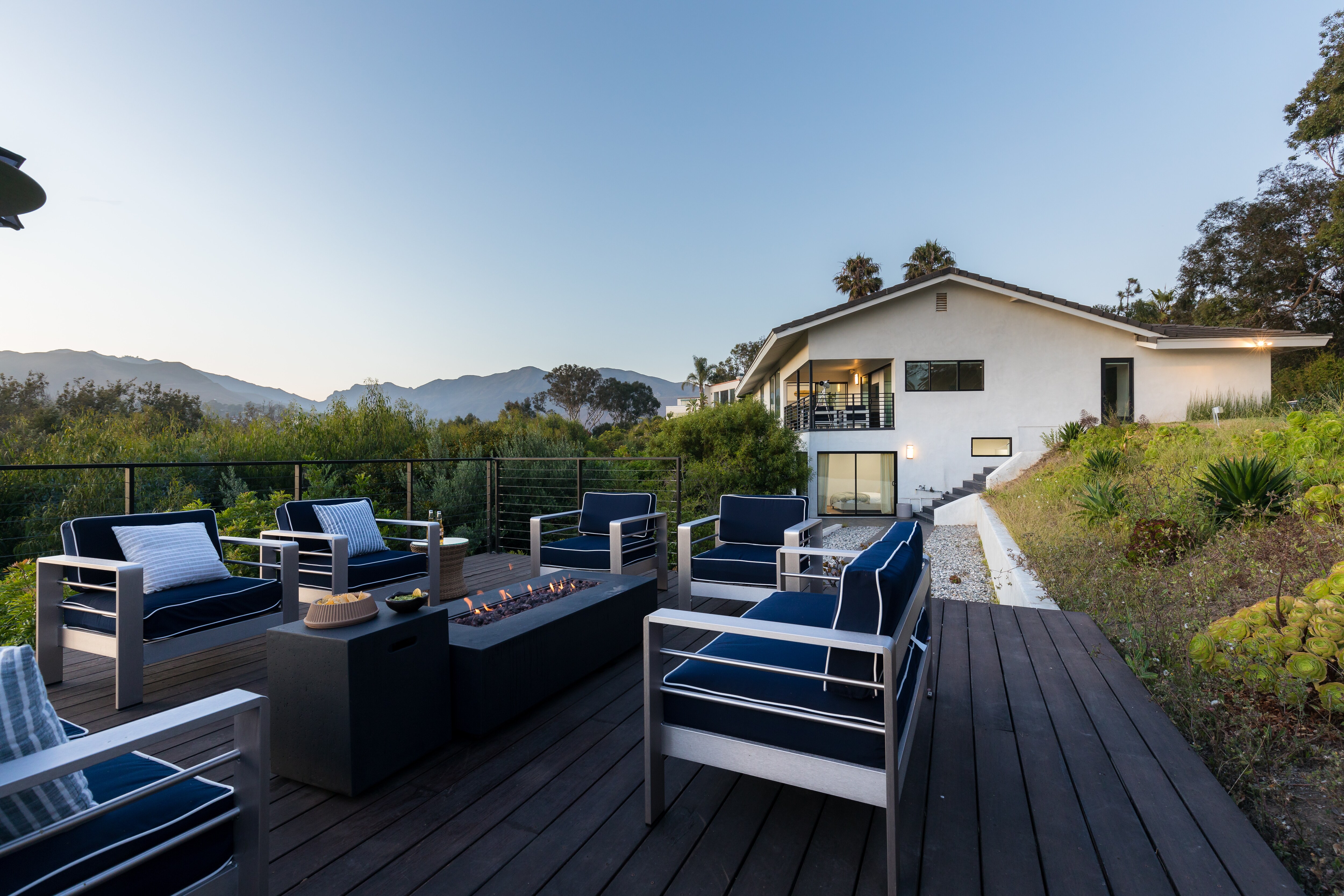 Outdoor patio with ocean and mountain view. Relax around the fire pit!