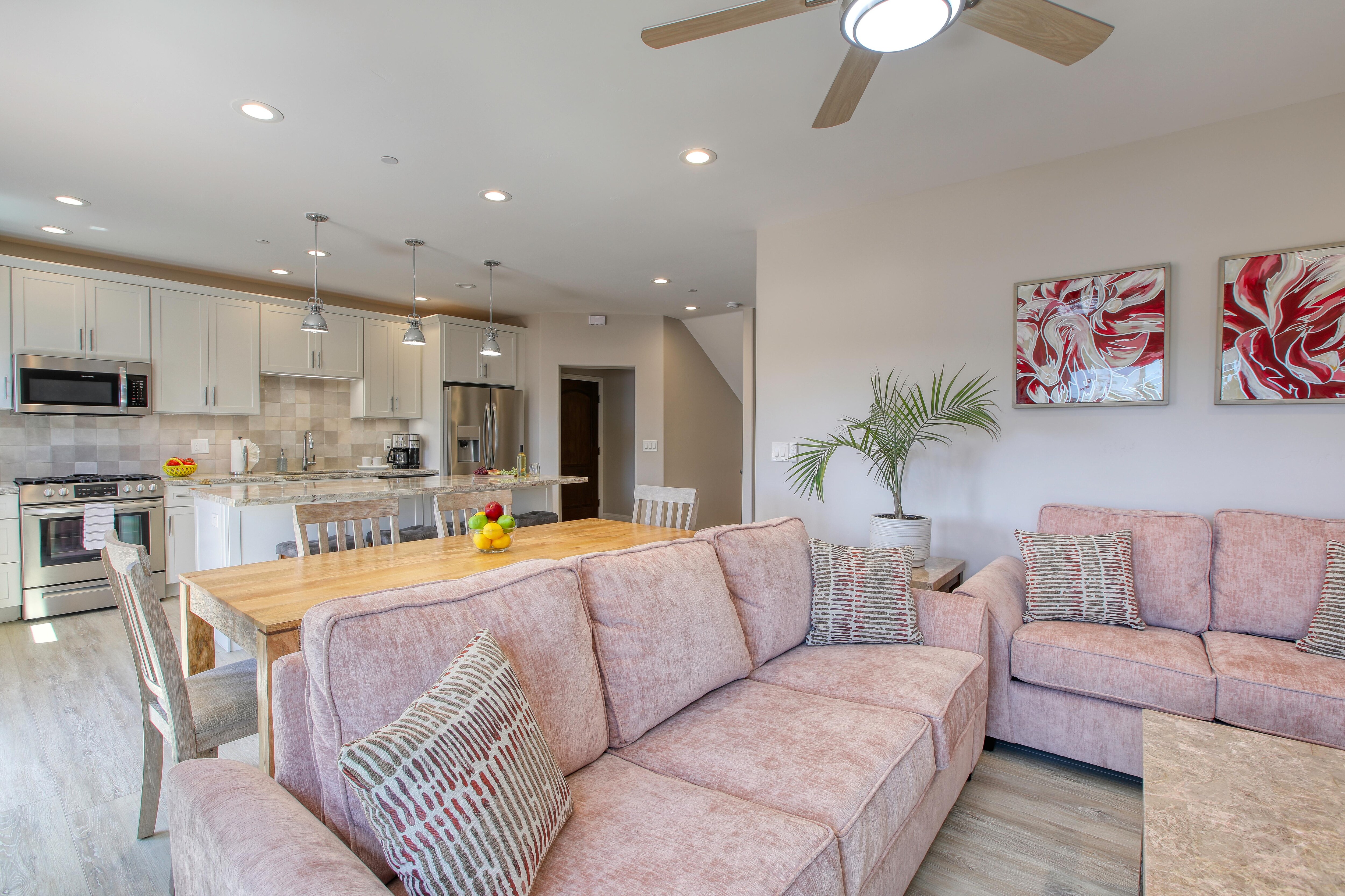 The living room boasts beach-inspired hues of blush and sand and is outfitted with a Smart TV, ready for your Netflix and other favorite entertainment channels. Ample seating arrangements invite family and friends to gather around the television, while the