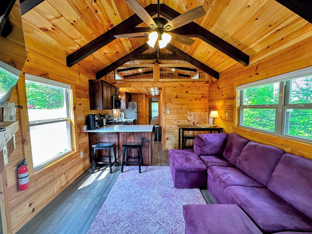 Living room with TV, fireplace and dining area with stools