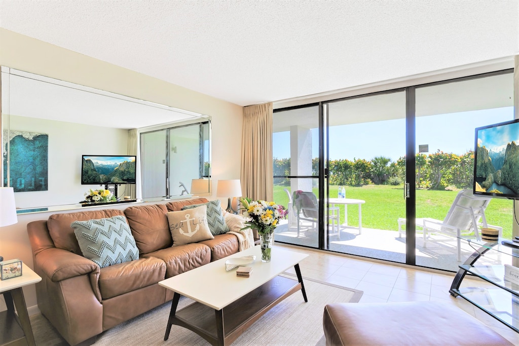 Relax in this cozy living room with 55" LCD TV and a stunning patio view of the ocean