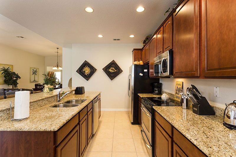Beautiful kitchen area with microwave, oven, double door refrigerator and barstool seating