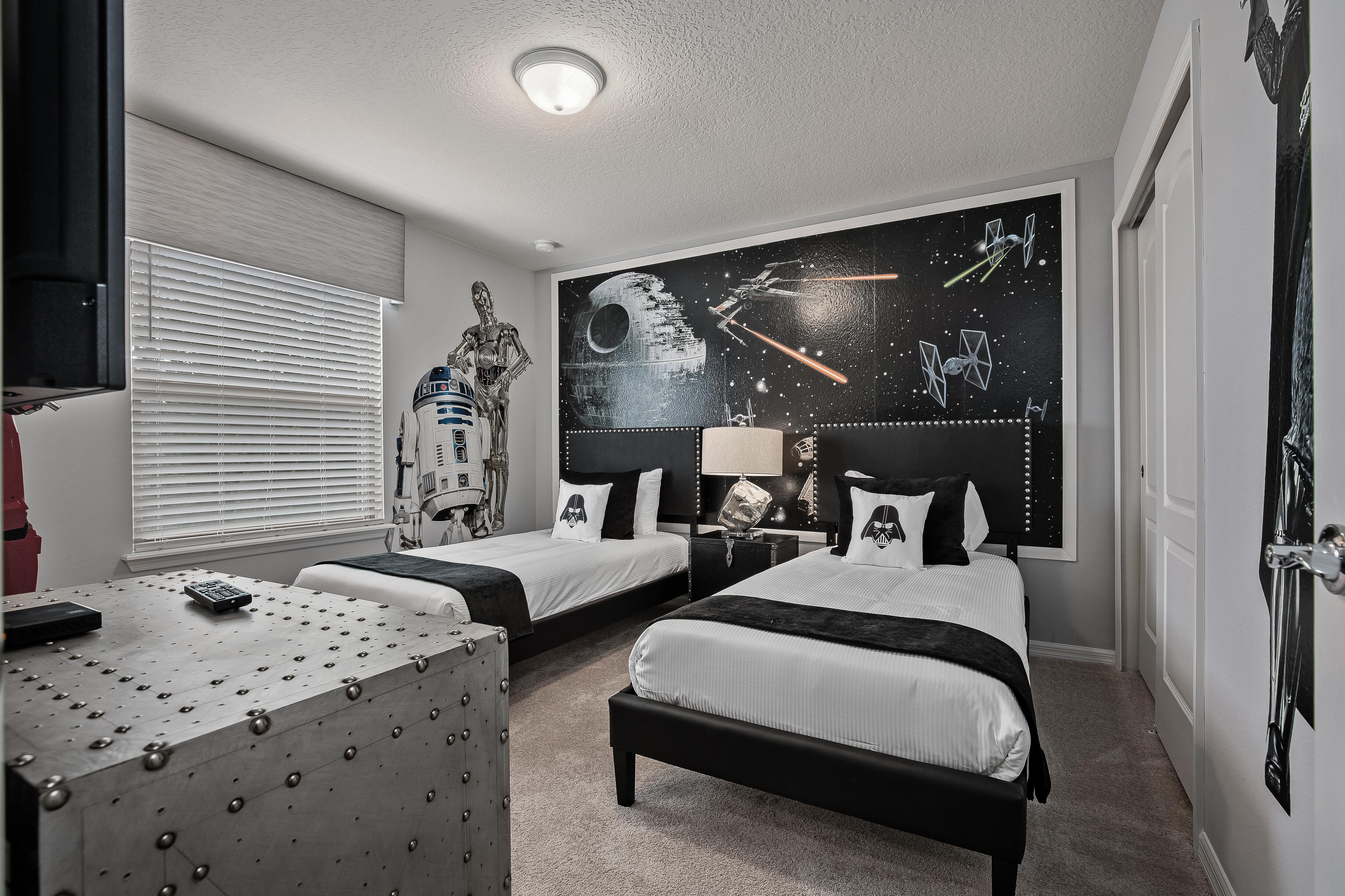 Star Wars themed bedroom with two twin beds and flat screen TV
