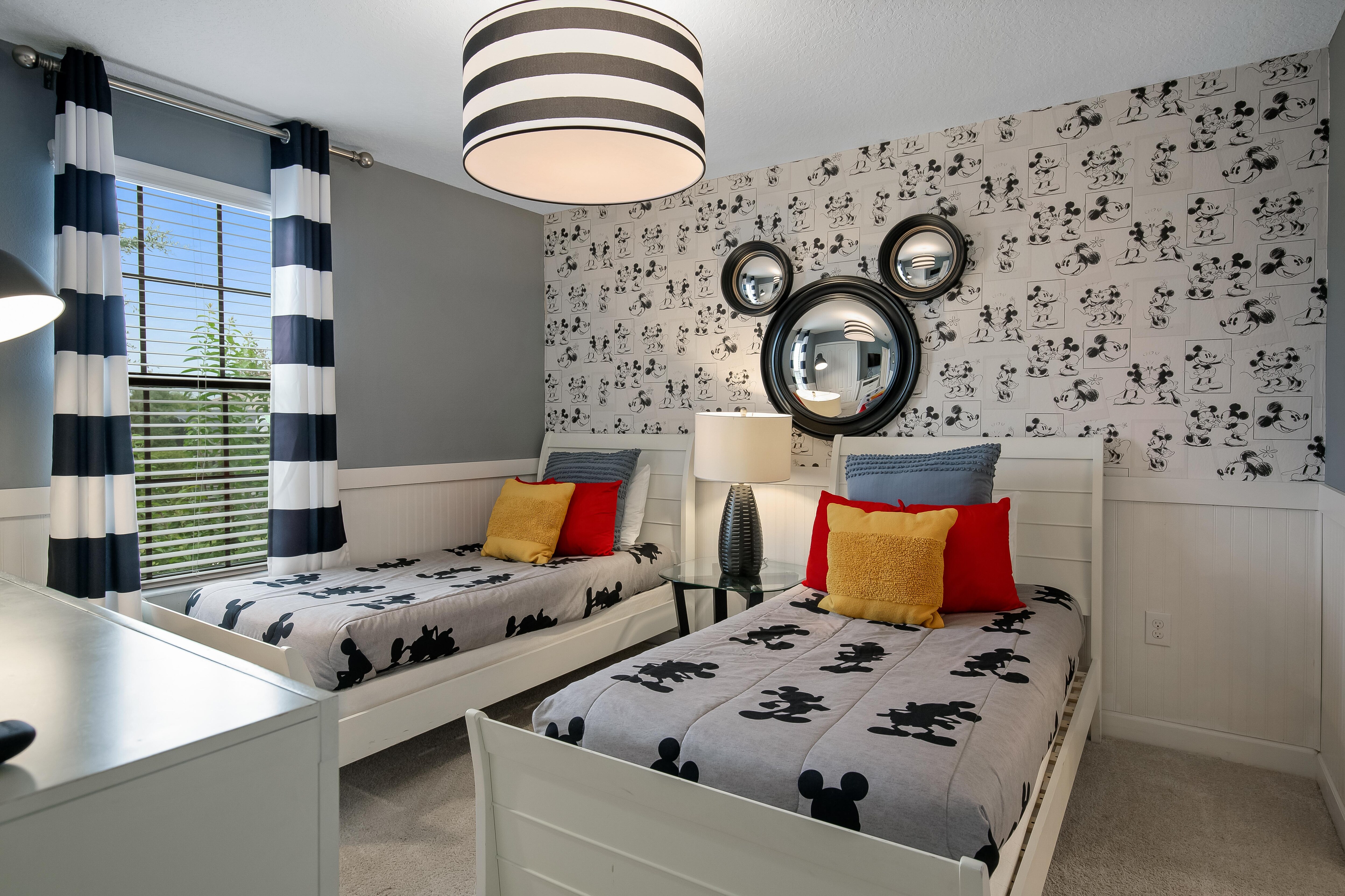 Adorable Mickey themed room with two twin beds and a flat screen TV