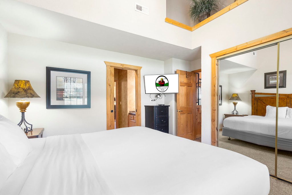 Rest easy in this bright and airy bedroom, featuring a plush bed, mirrored closet, and private TV for ultimate comfort.