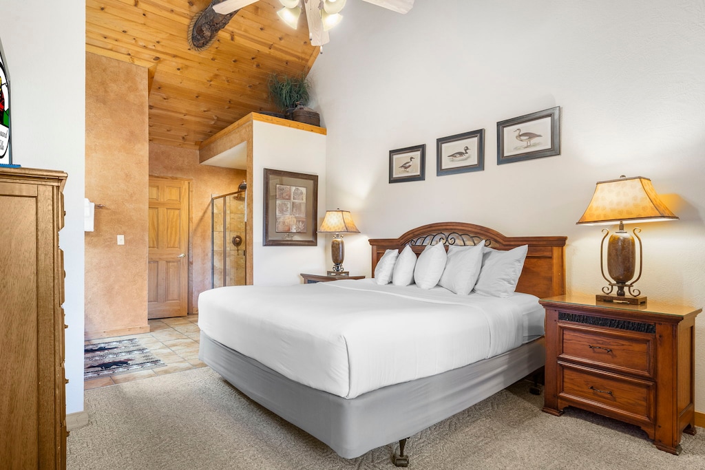 Spacious bedroom with vaulted ceilings, a private TV, and direct access to the loft and an ensuite bath