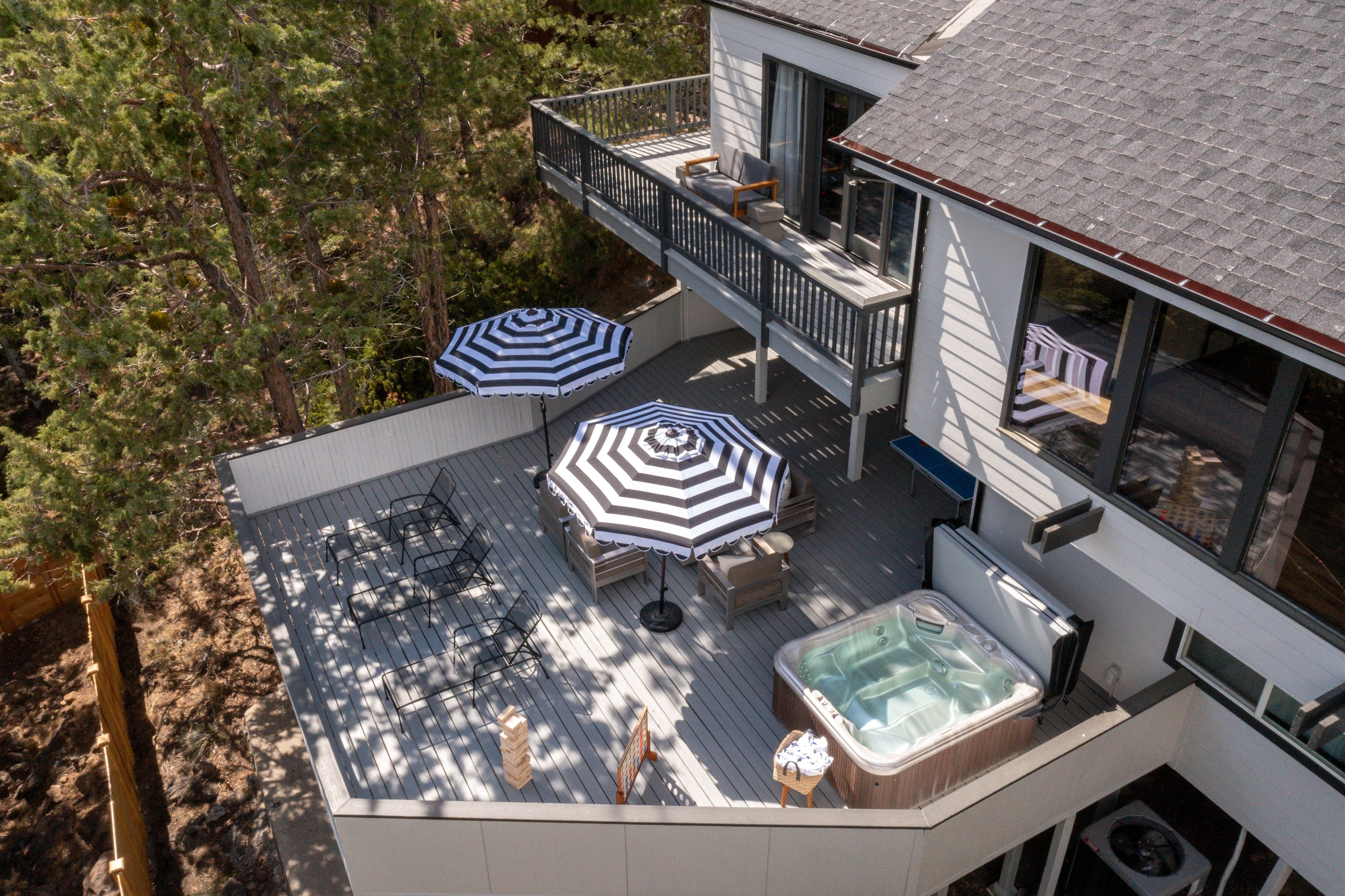 Multiple spacious decks with hot tub, fire pit, dining, ping pong, and all around lounging.