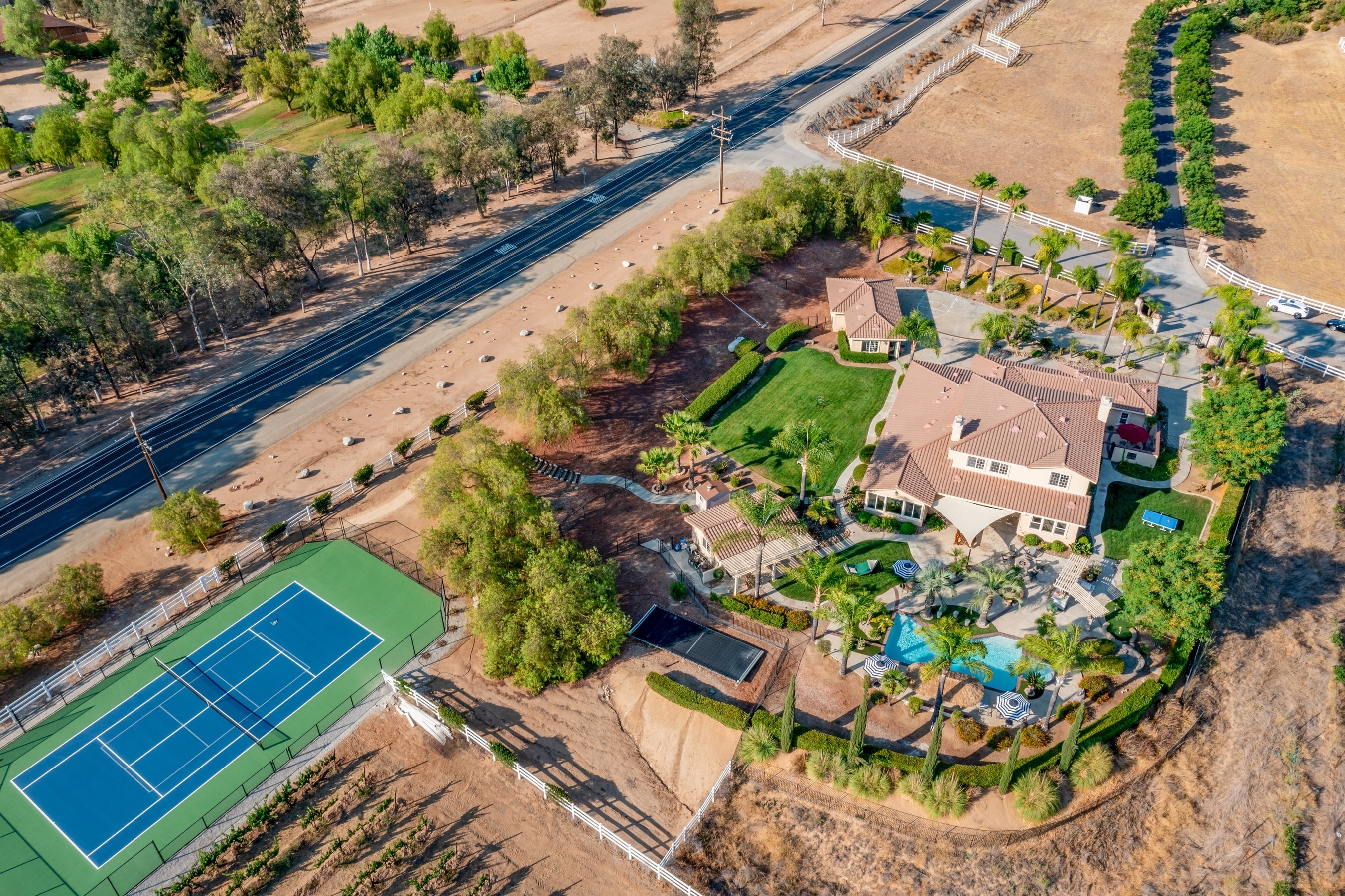 Amazing property with pool, spacious lawn, patio, basketball, putting green, and tennis court.