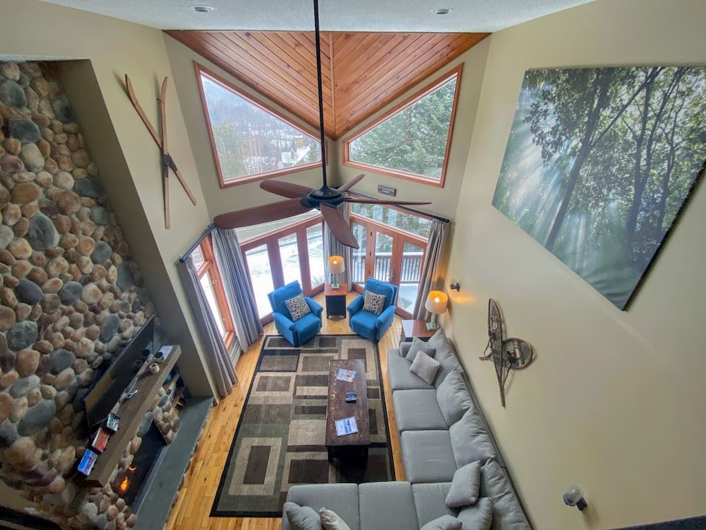 Inside it offers an open-concept living, dining, and kitchen area featuring vaulted ceilings, large TV, and a stunning stone fireplace.