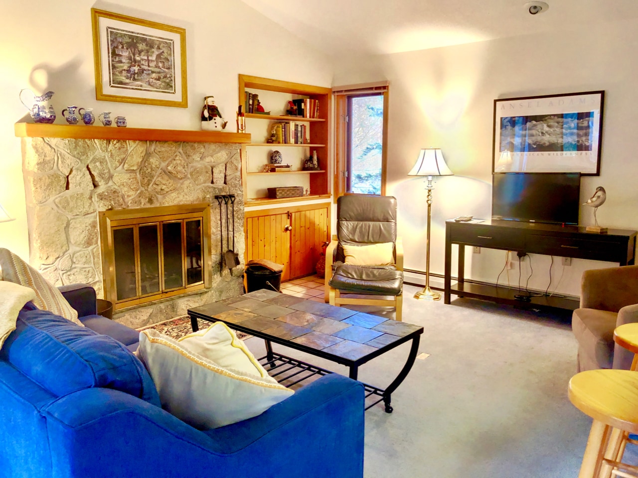 Dining/Living Area: Open concept space with cozy dining table that seats 4 and comfortable furniture that surrounds the stone fireplace.