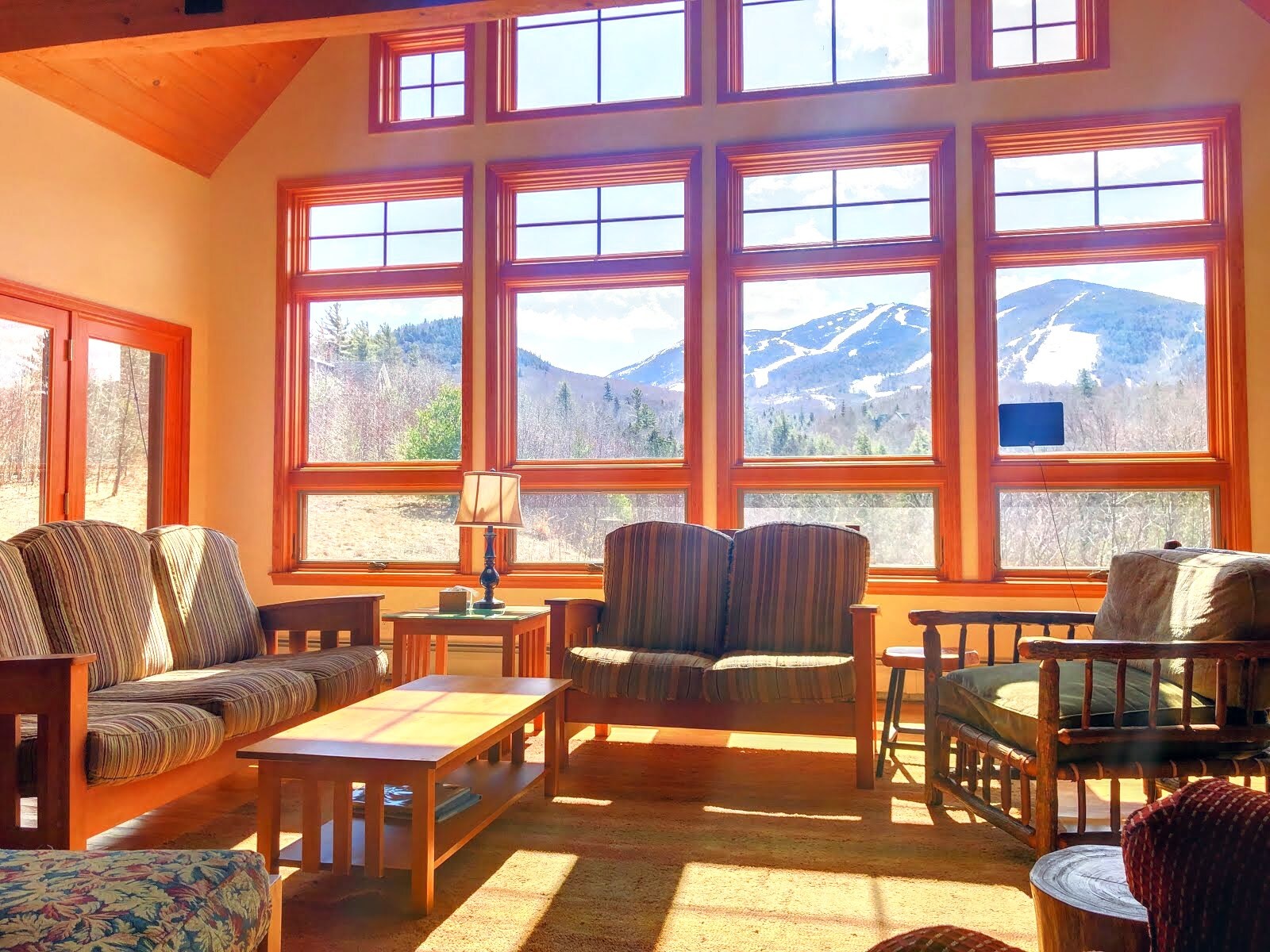 The beautiful rustic furniture perfectly positioned to soak in the majesty of Cannon Mountain and the Kinsman Range towering right in front of you.