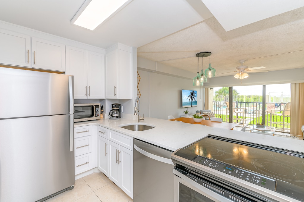 Cook with a view! This sleek kitchen flows into the living area and out to the poolside patio