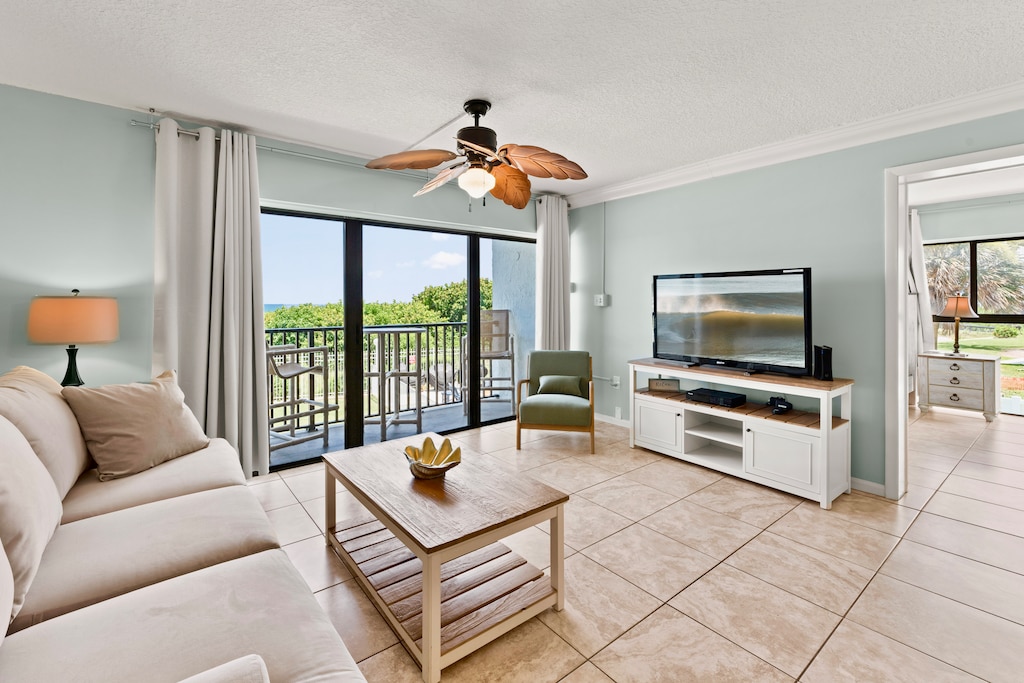 Bright and airy living room with a ceiling fan and stunning balcony views