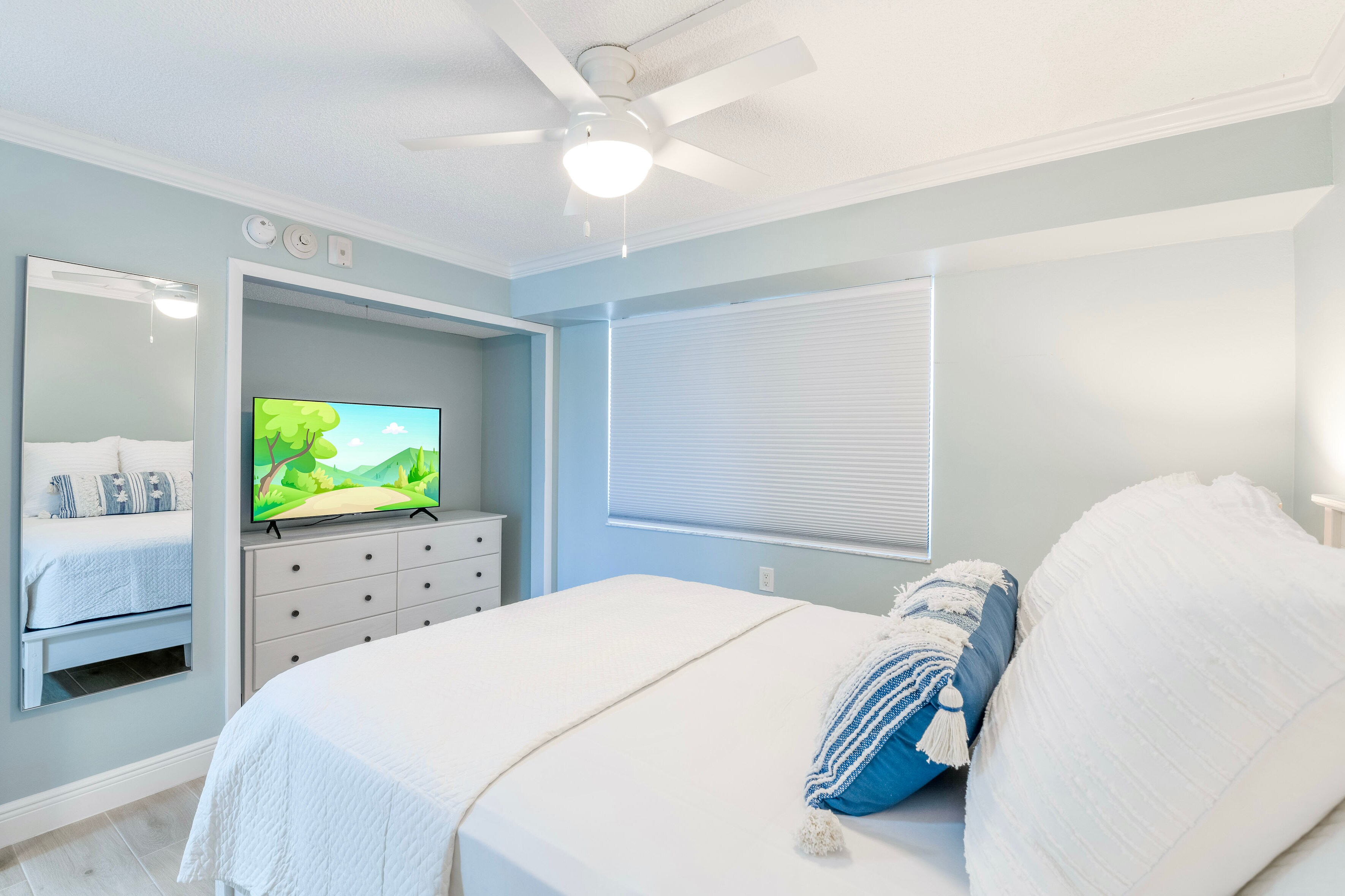 Guest bedroom with queen sized bed and flat screen TV.