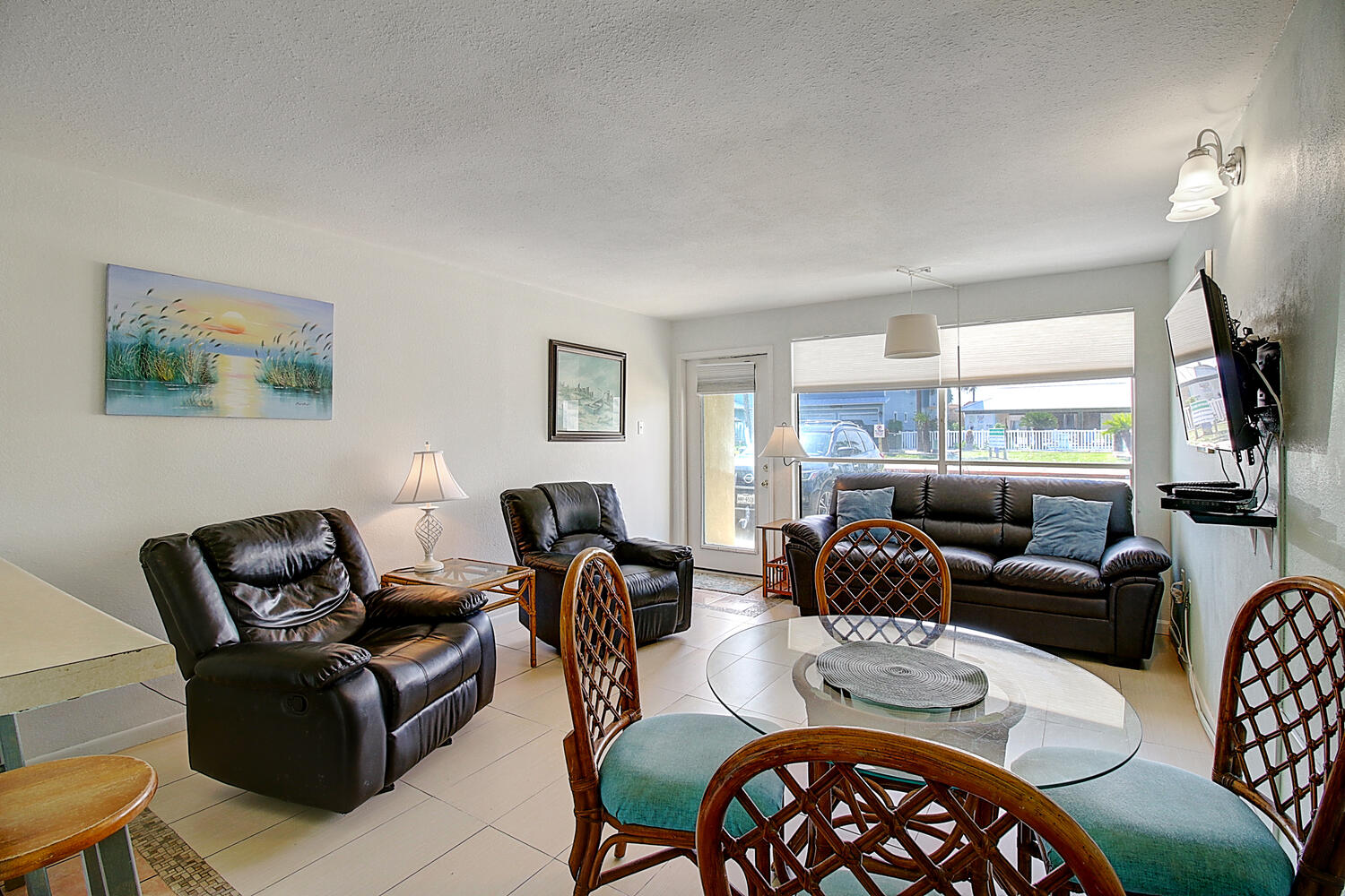 Living room and dining room. Beachy vibes in a spacious, yet cozy conjoined living, dining, and kitchen areas