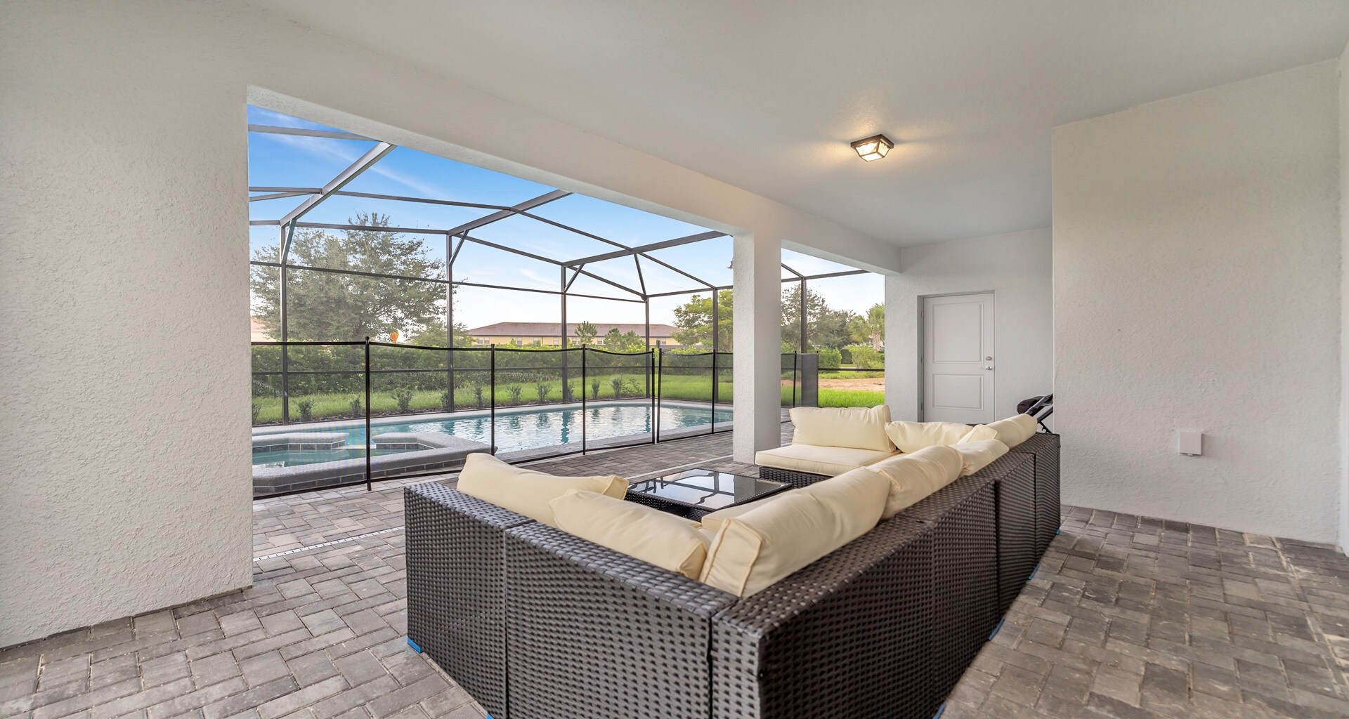 Comfortable seating captivating the view of the outdoor pool, creating a relaxing and scenic spot.