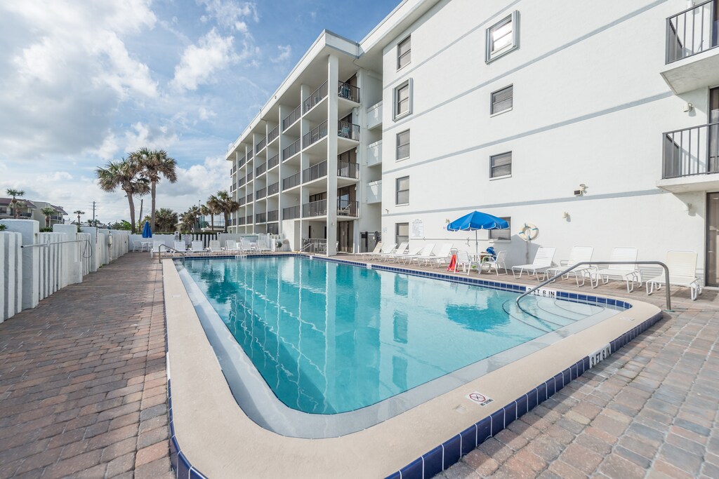 Sparkling outdoor heated pool and hot tub with plenty of lounge space for relaxation.