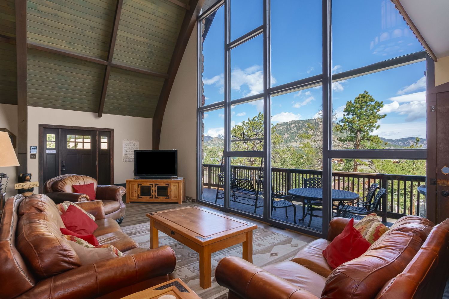 Sky View in the Rockies - Living Room features floor to ceiling  windows overlooking the deck with mountain views
