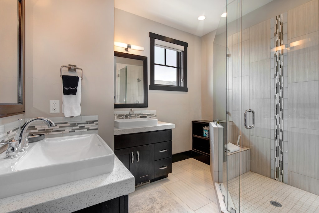 Upper Level Master Bathroom with two separate vanities, large tiled shower with bench and separate washroom area
