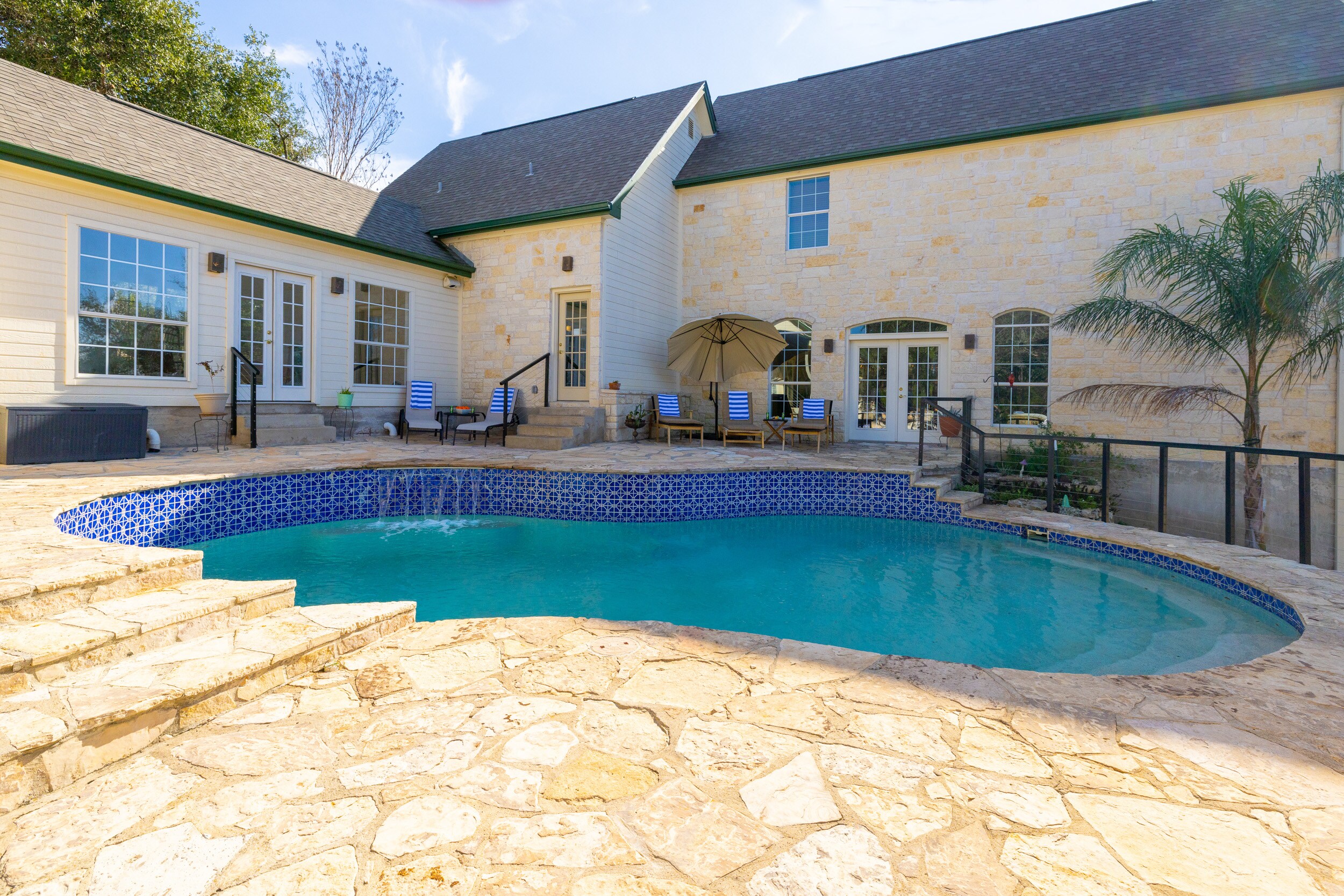 Pool with a Waterfall Feature and Patio Seating