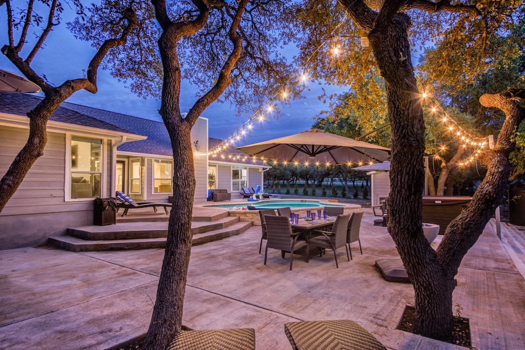 Resort-style living!  Huge back patio.  Beautiful heated pool, hot tub, putting green, multi-use sport area, and fire pit all on 2 acres of privacy in Hill Country.  Plenty of outdoor seating for the whole family.