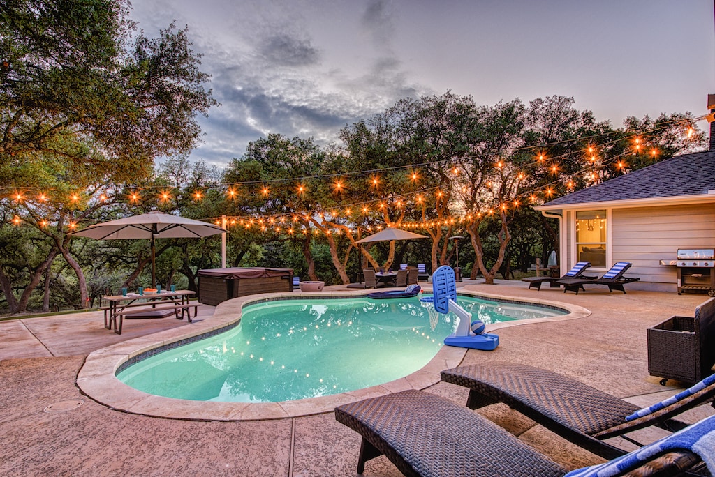 Resort-style living!  Beautiful heated pool, hot tub, putting green, multi-use sport area, and fire pit all on 2 acres of privacy in Hill Country