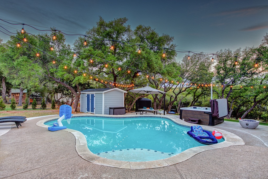Resort-style living!  Beautiful heated pool, hot tub, putting green, multi-use sport area, and fire pit all on 2 acres of privacy in Hill Country