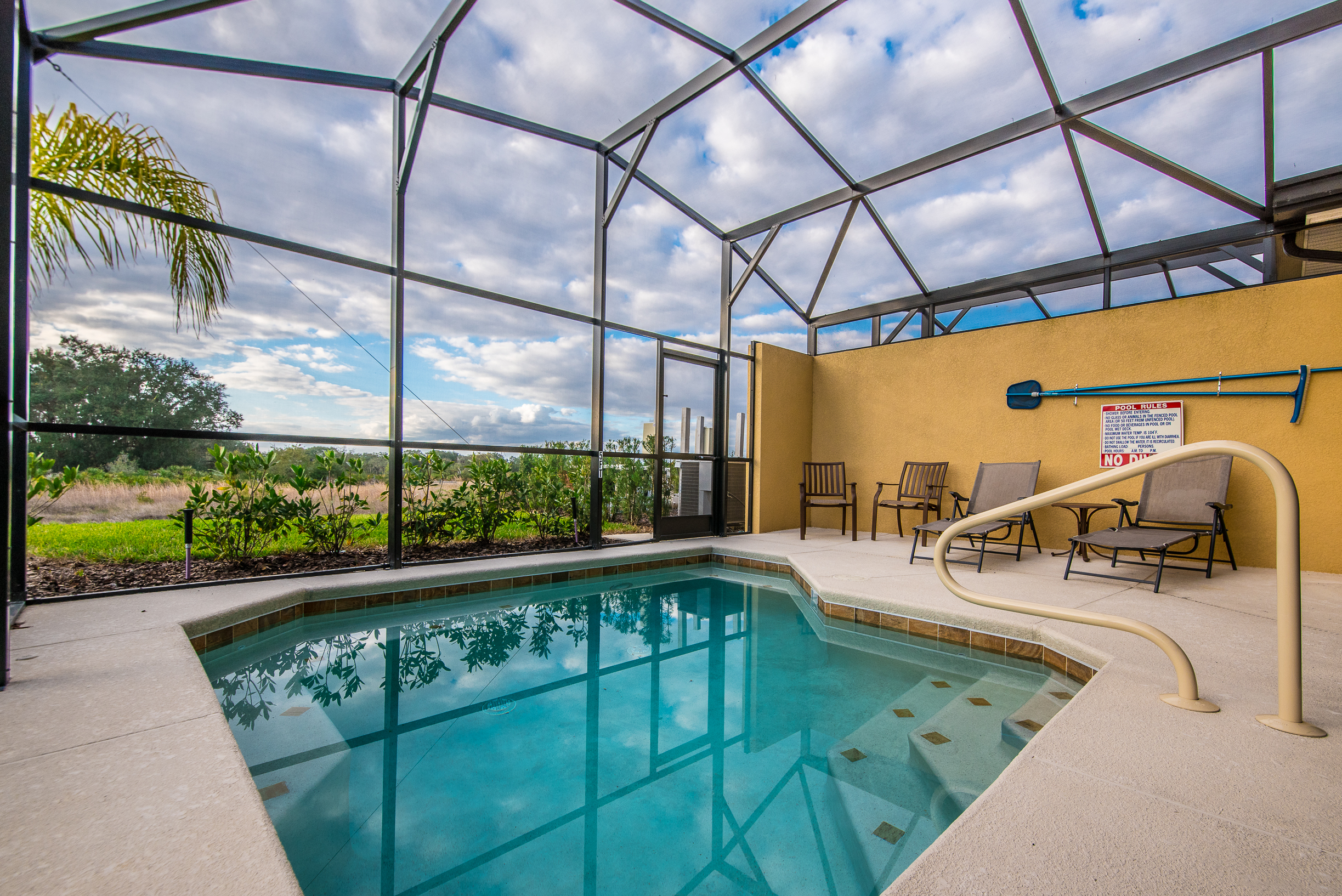 Welcoming private pool of the townhouse in Davenport Florida - Lounge chairs for you to relax - Glistening waters inviting you to take a refreshing swim - A tranquil setting where you can unwind and soak up the beauty of your surroundings