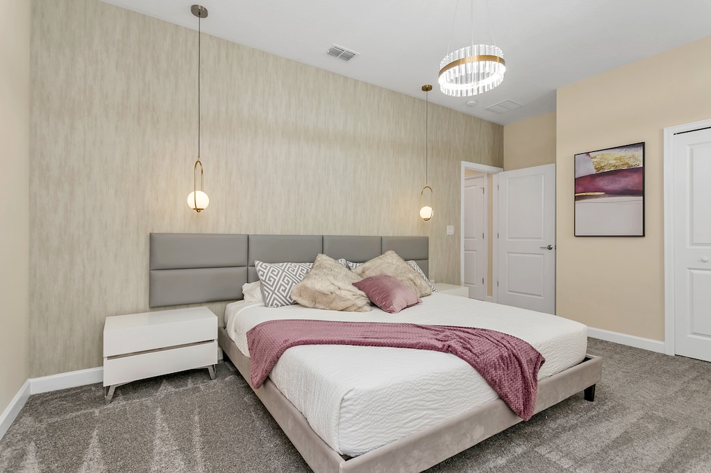 Spacious bedroom of the home in Kissimmee Florida - Modern and stylish decor that complements the space - Bedroom with a cozy ambiance, blending comfort and aesthetics - Stylish double bed design with plush bedding