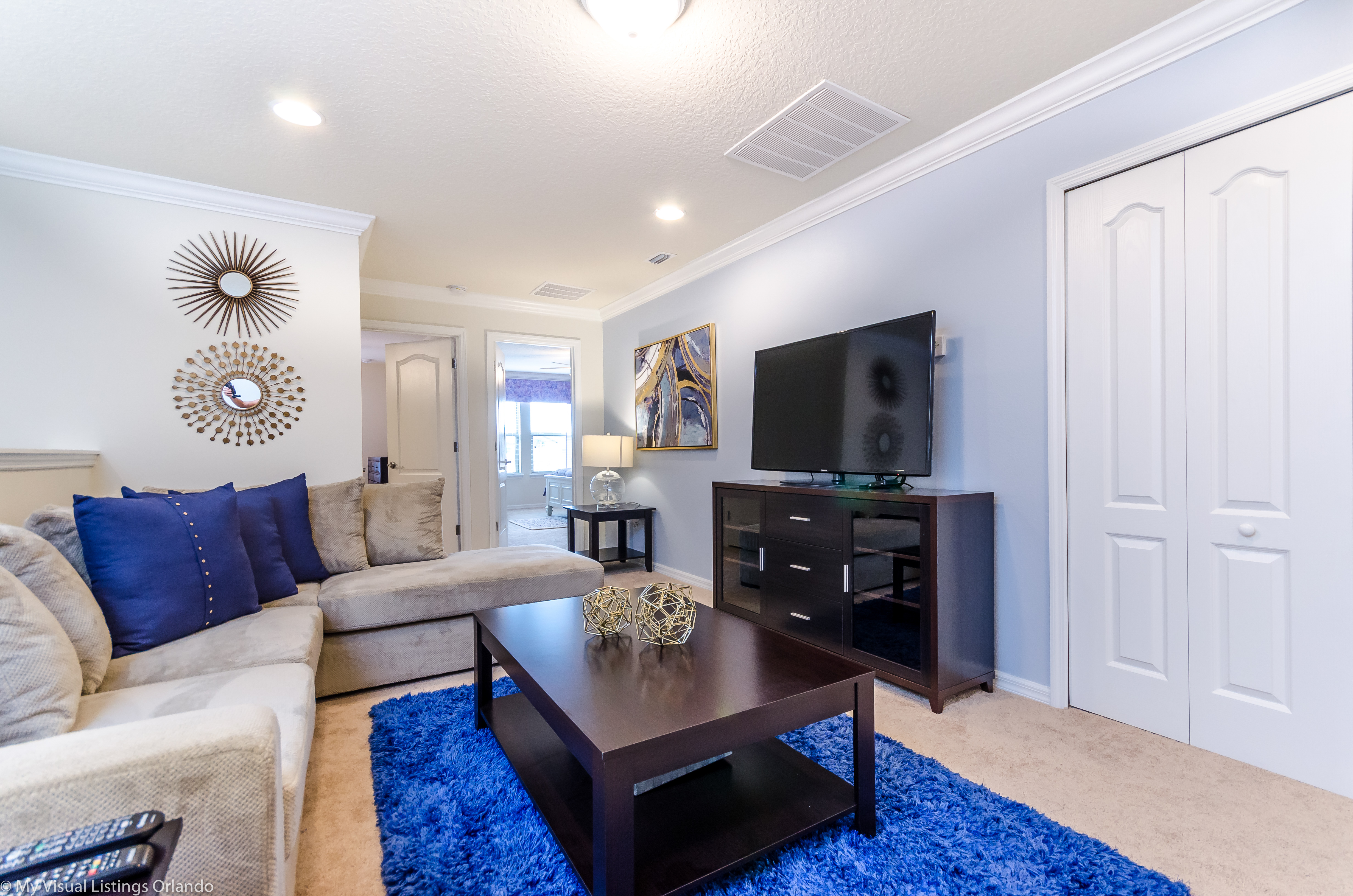 Step into the spacious living room, where relaxation meets entertainment with a prominent TV setup. A haven of comfort and leisure, promising ample space for shared moments and cinematic adventures.