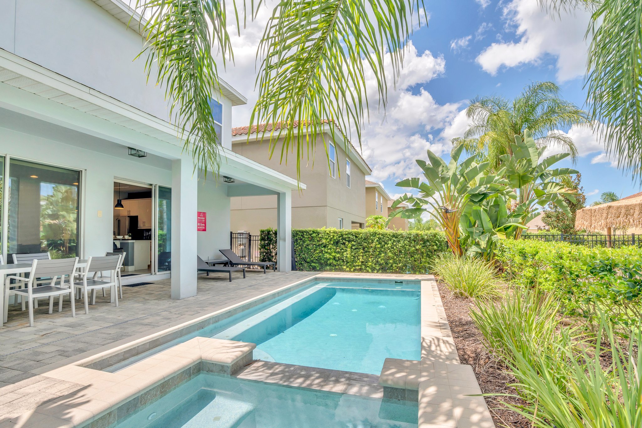 Stunning Pool Area of the Apartment in Kissimmee Florida - Tranquility by the sparkling water - Immerse yourself in the cool elegance - Discover bliss by the pool in serene setting - Palm trees and tropical plants enhance the vacation feel