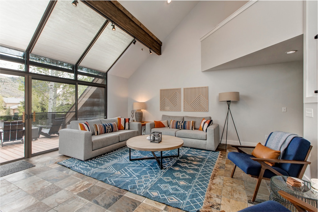 Main Level Living Room with floor to ceiling windows, gas fireplace, plush furnishings with sofa sleeper, 75" Samsung smart tv, and breathtaking views of Deer Valley