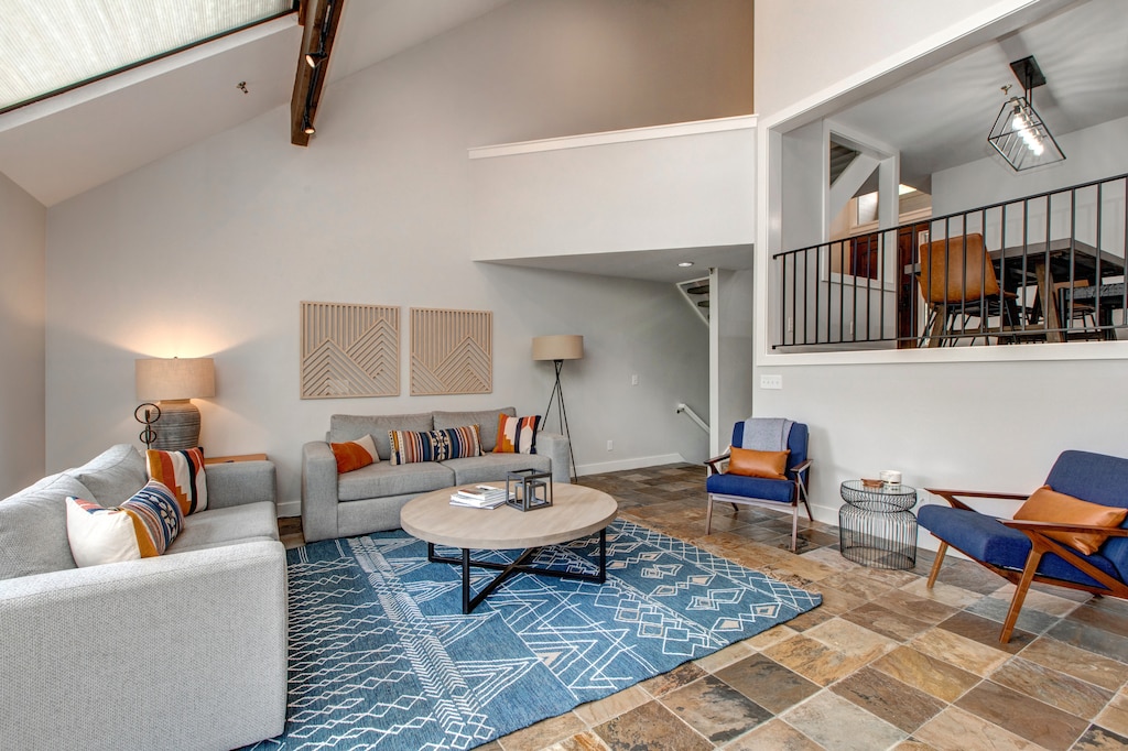 Main Level Living Room with floor to ceiling windows, gas fireplace, plush furnishings with sofa sleeper, 75" Samsung smart tv, and breathtaking views of Deer Valley