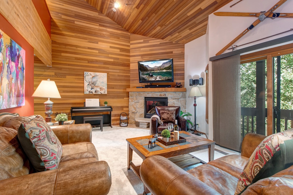 Living Room with plush leather furnishings, 50" TV, gas fireplace, piano, wall-mounted stereo system, and private balcony access