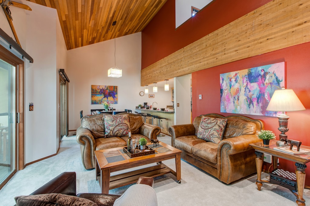 Living Room with plush leather furnishings, 50" TV, gas fireplace, piano, wall-mounted stereo system, and private balcony access