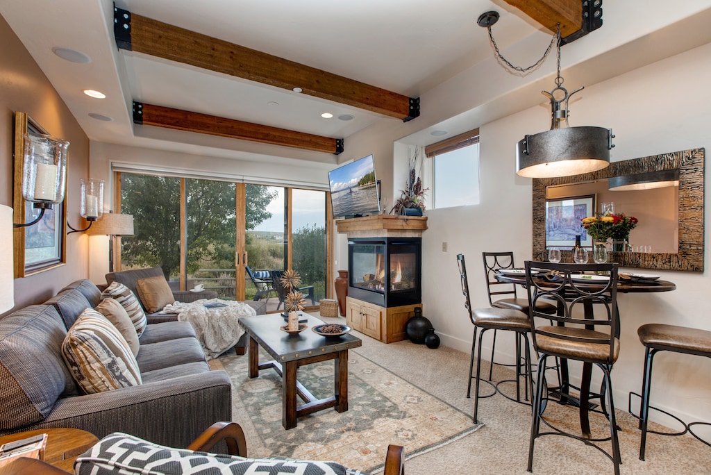 Living Room with plush sofa and lounger, gas fireplace, 55" TV, private patio access and breath-taking views of the Swaner Nature Preserve